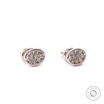 Close up of dainty white gold stud earrings with lab grown diamonds in oval shape.