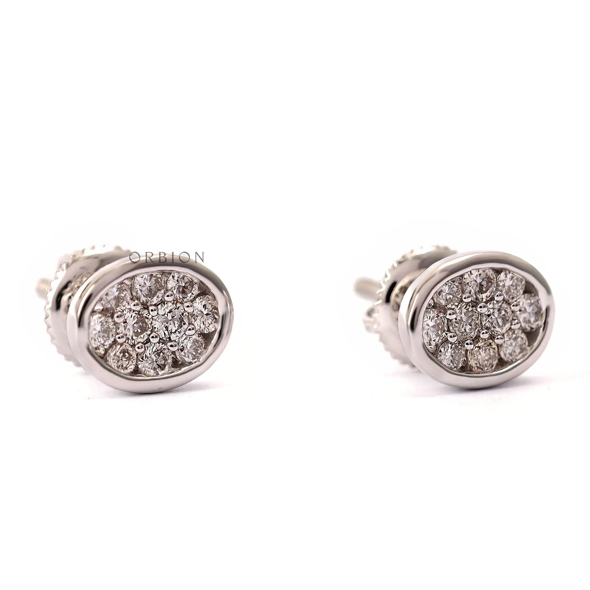 Close up of dainty white gold stud earrings with lab grown diamonds in oval shape.