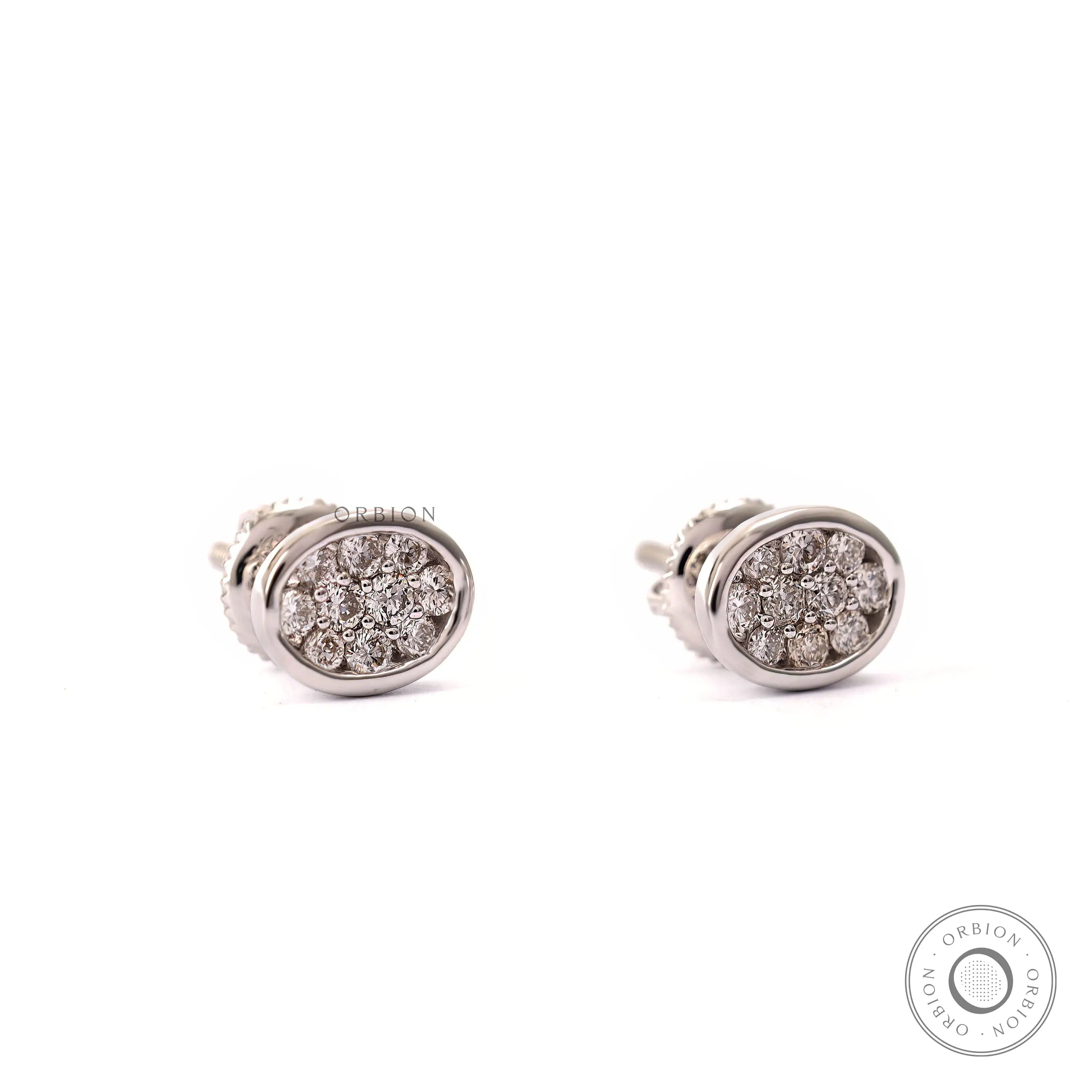 Close up of dainty white gold stud earrings with lab grown diamonds in oval shape.