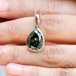 Dark green bezel set moissanite pendant close up