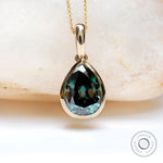 Pear shaped dark green moissanite bezel pendant in 14K yellow gold