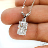 Close up of elongated cushion diamond pendant with accent stone.