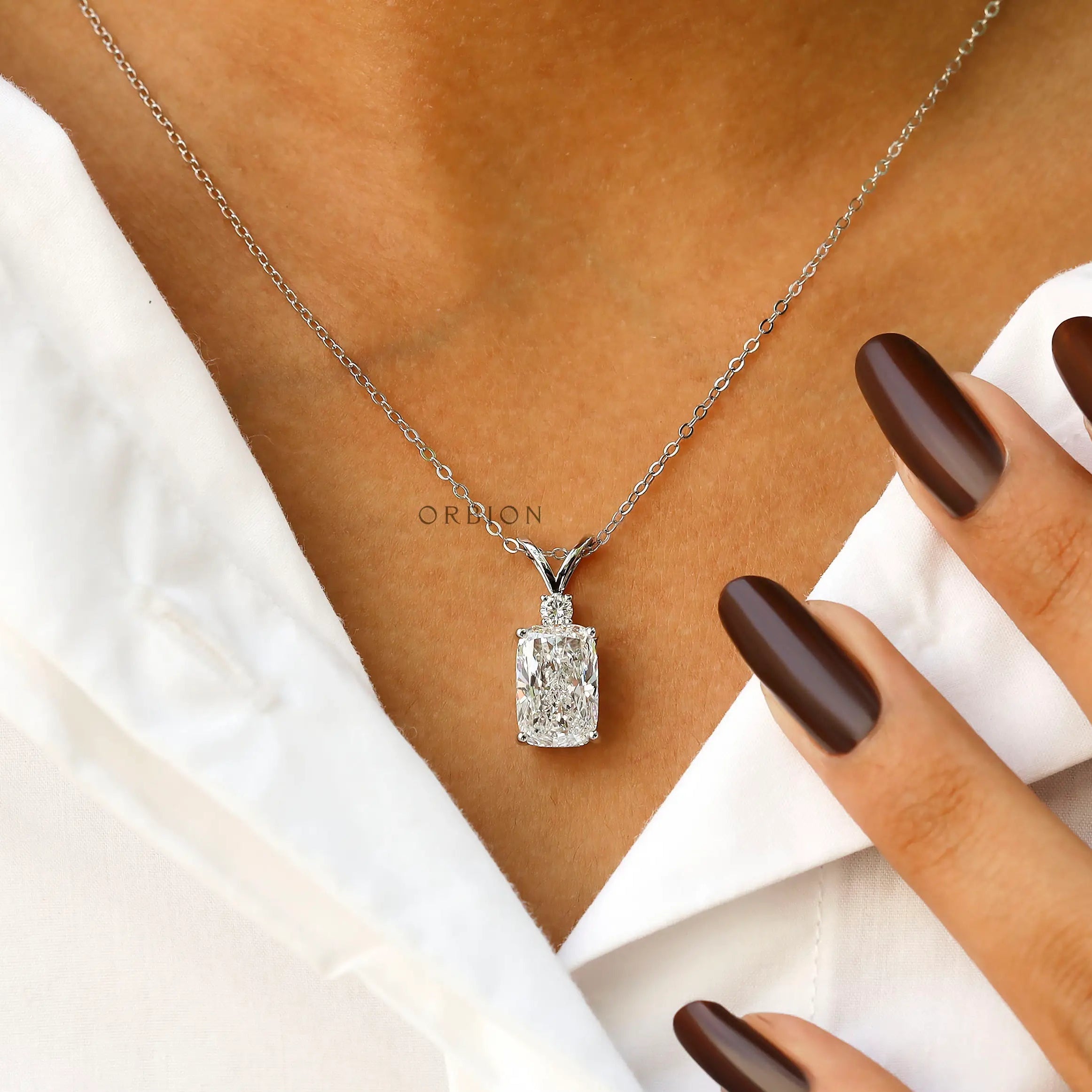 Worn neck view of elongated cushion diamond pendant necklace.