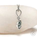 Light blue green moissanite pendant close up in white gold