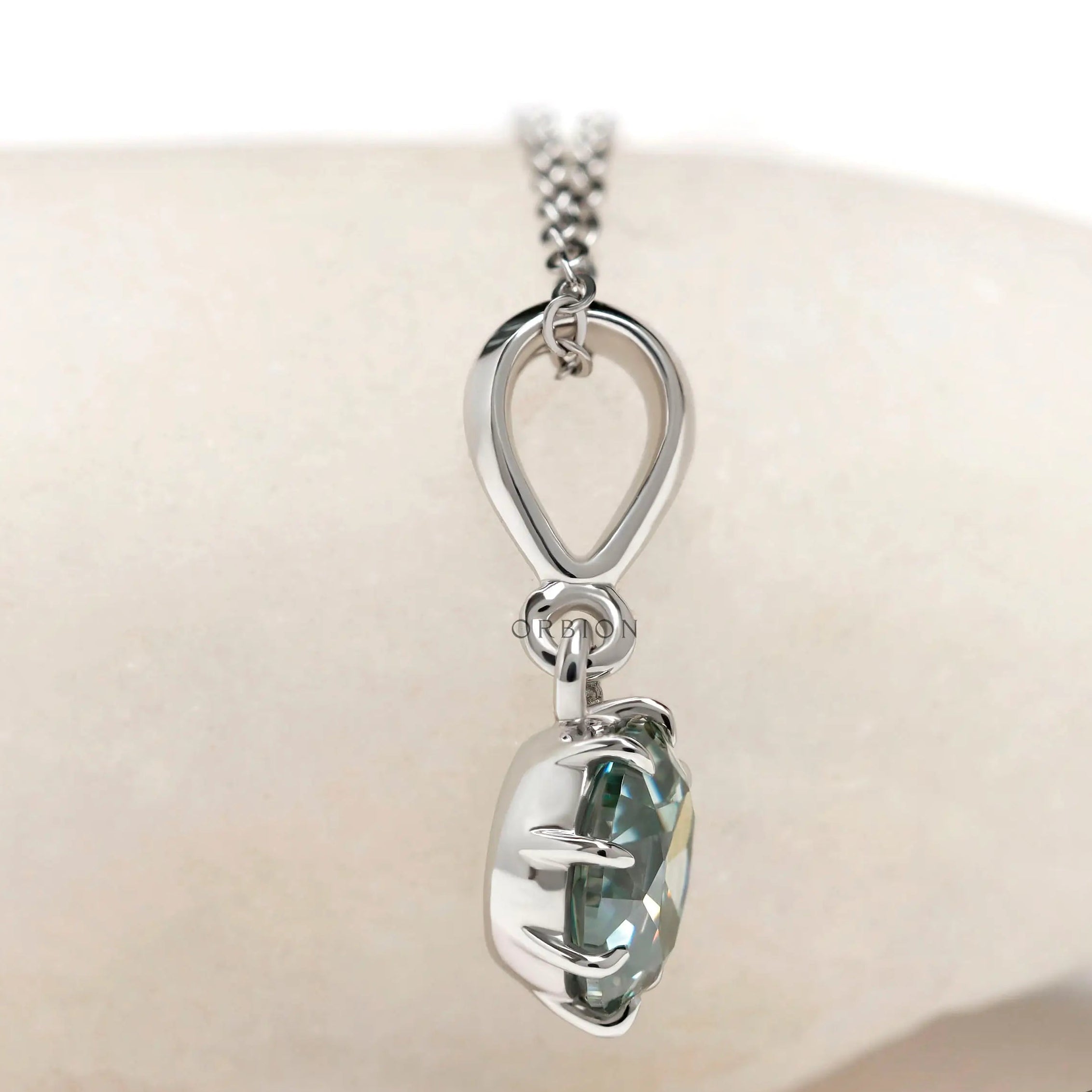 Light blue green moissanite pendant close up in white gold