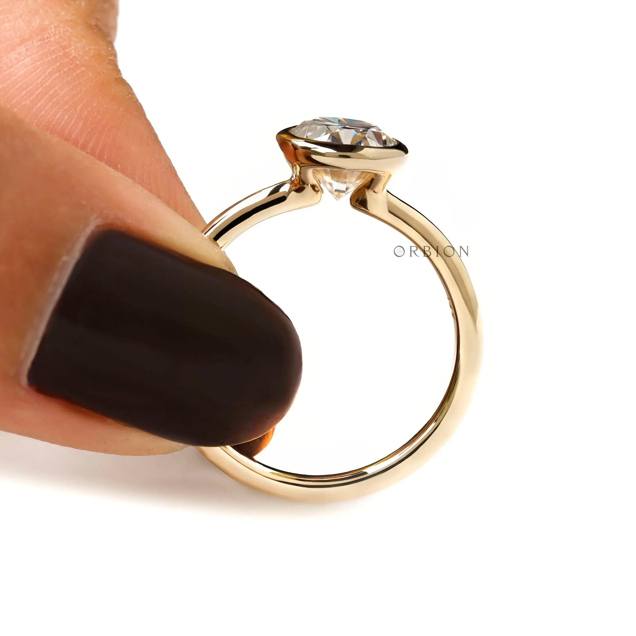 Hand shot of oval bezel set engagement ring floating style