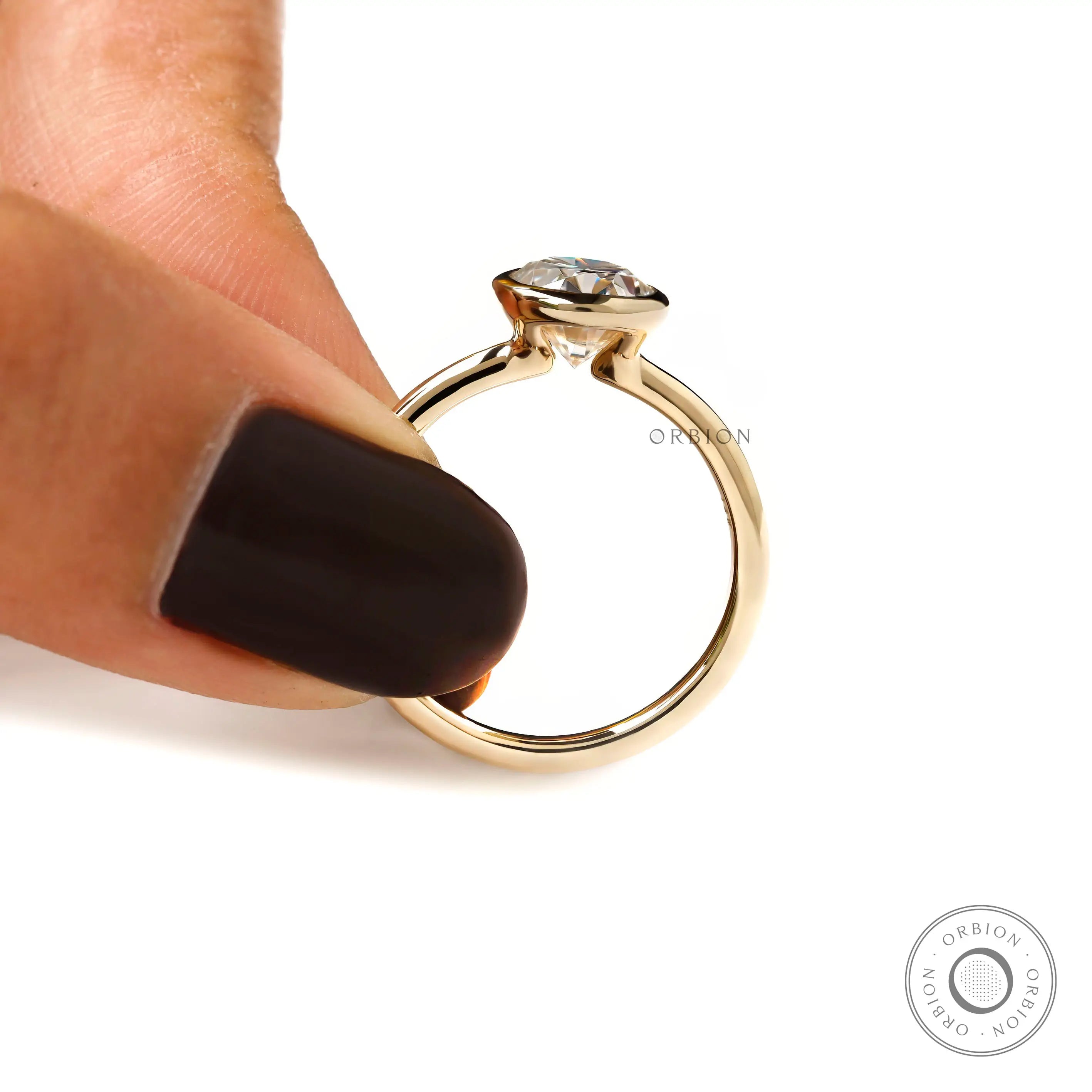 Hand shot of oval bezel set engagement ring floating style