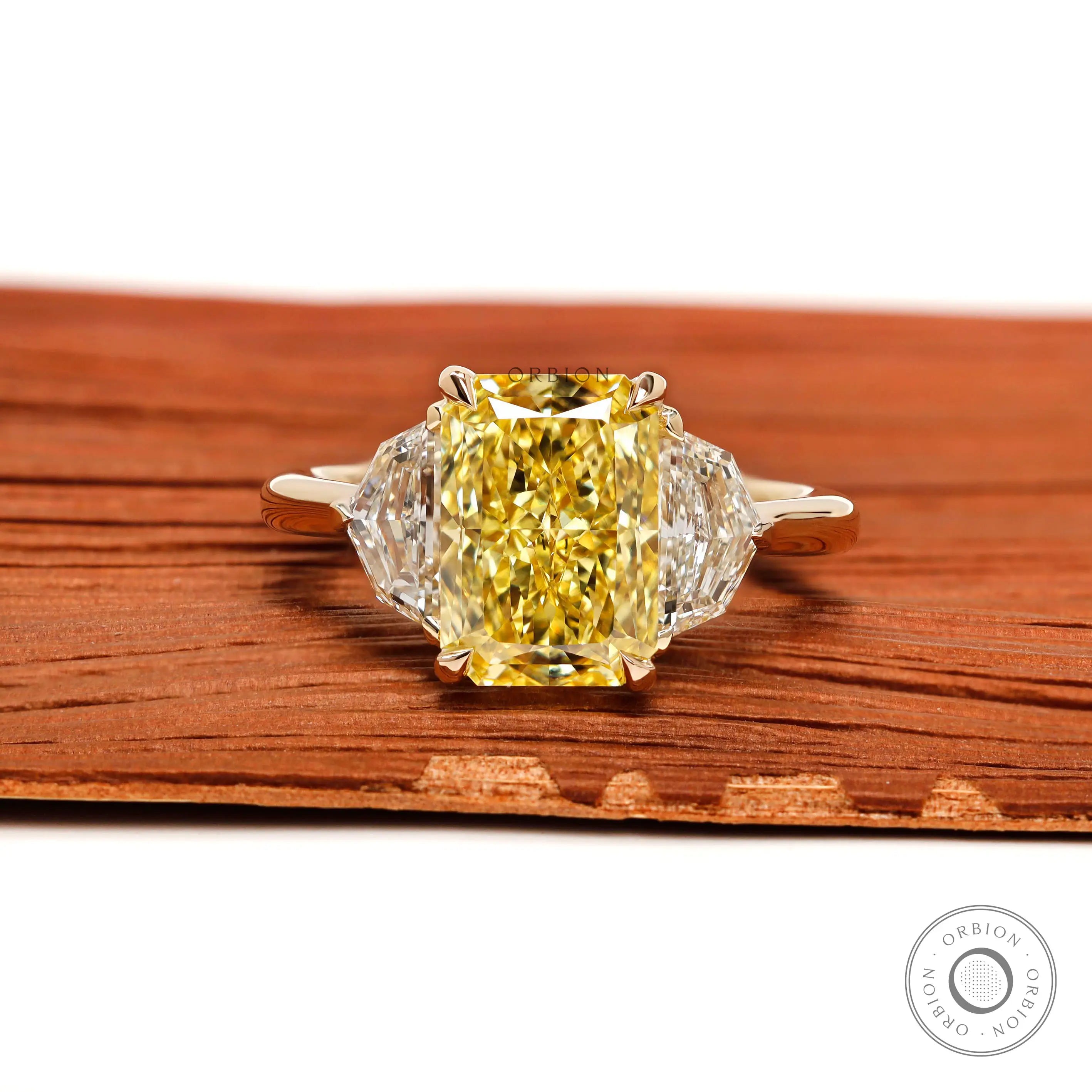 Radiant cut yellow diamond three stone engagement ring front view