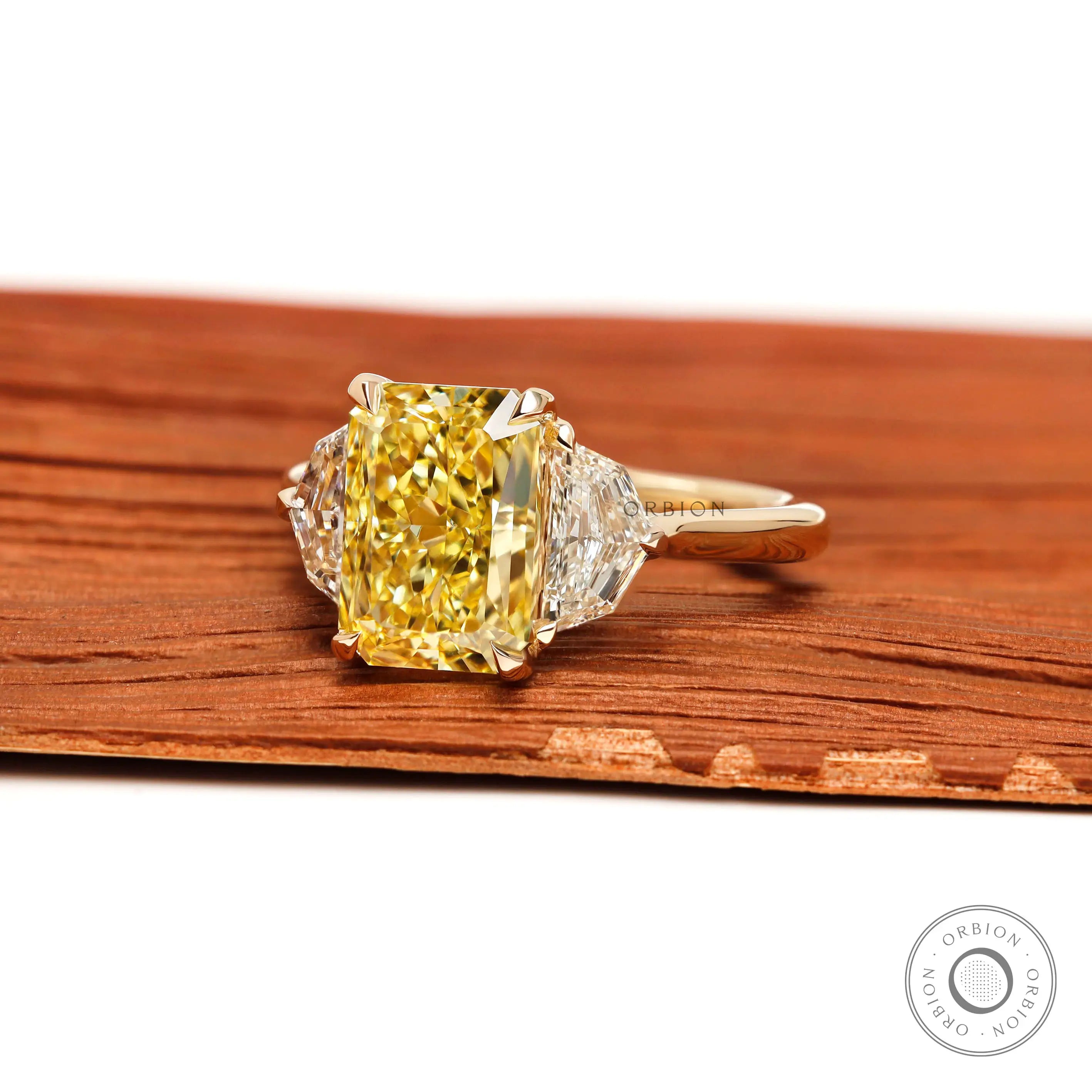 Angled view radiant yellow lab diamond ring with epaulette side stones