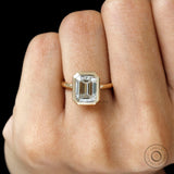 emerald cut moissanite bezel engagement ring with pave halo close up