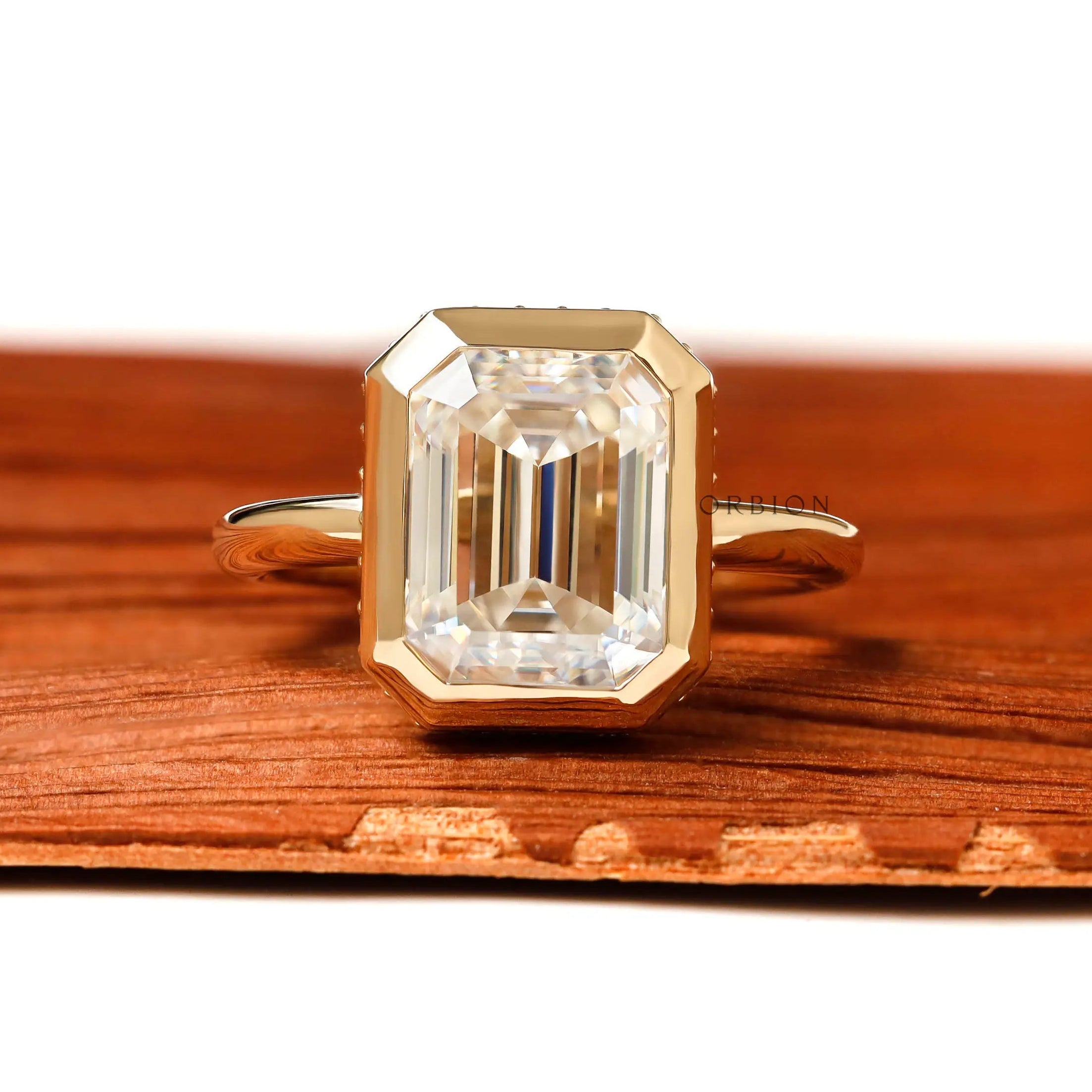 emerald cut moissanite bezel engagement ring with pave halo detail