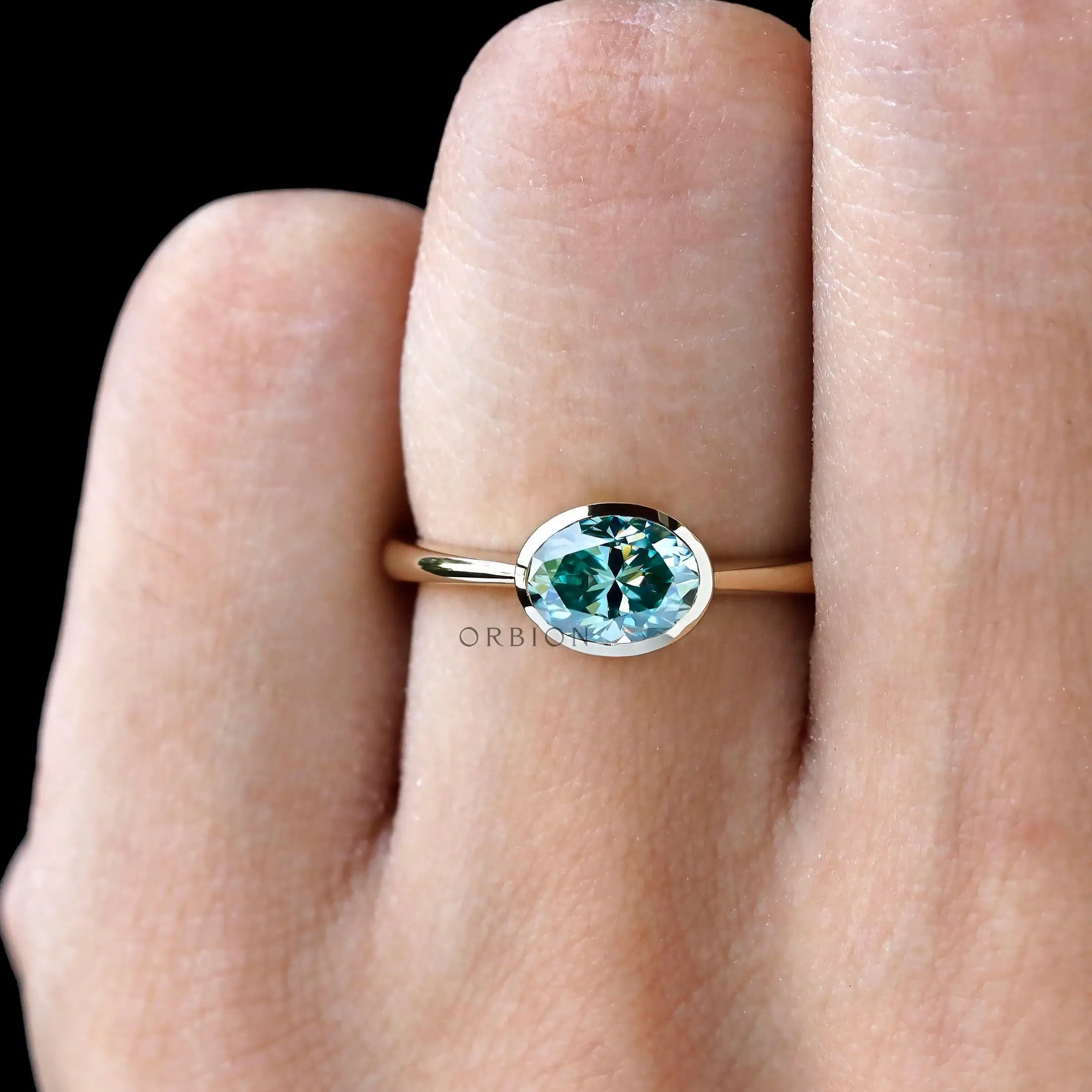 Bezel set oval teal moissanite promise ring yellow gold