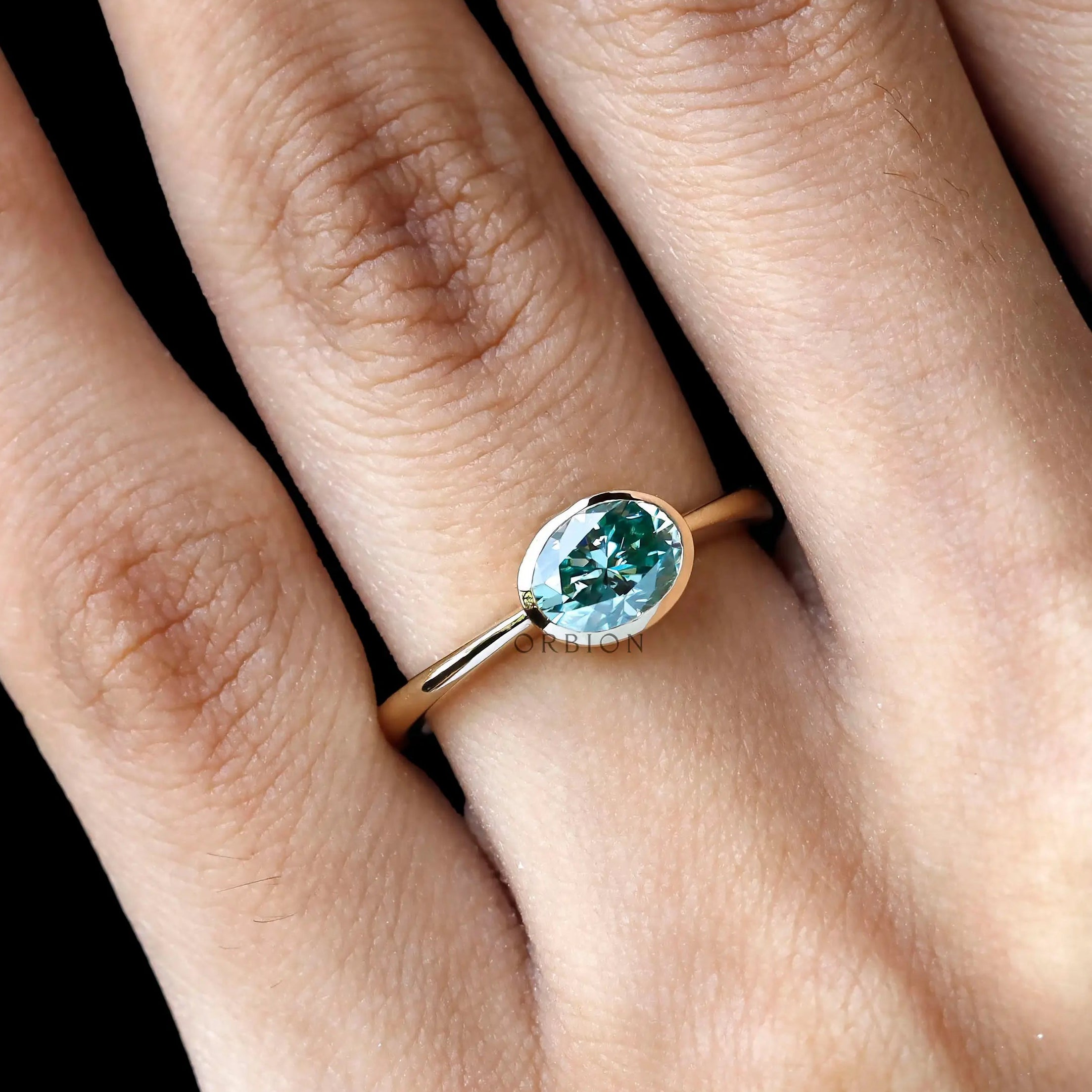 Oval east west blue green moissanite ring yellow gold