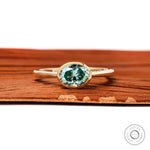 Blue green oval moissanite east west bezel set engagement ring in 10k yellow gold