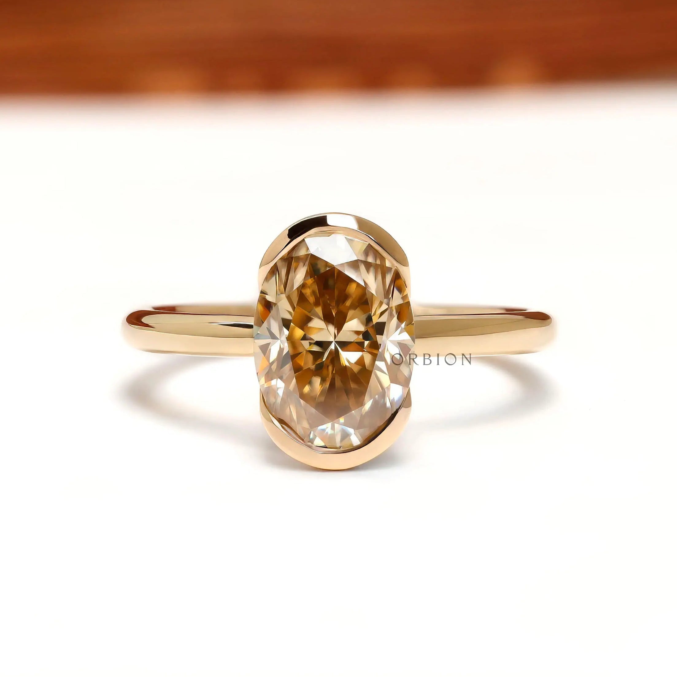 Front view oval light champagne moissanite half bezel floating engagement ring in 14k yellow gold