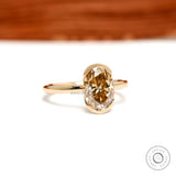 Centered closeup of oval champagne moissanite in floating bezel