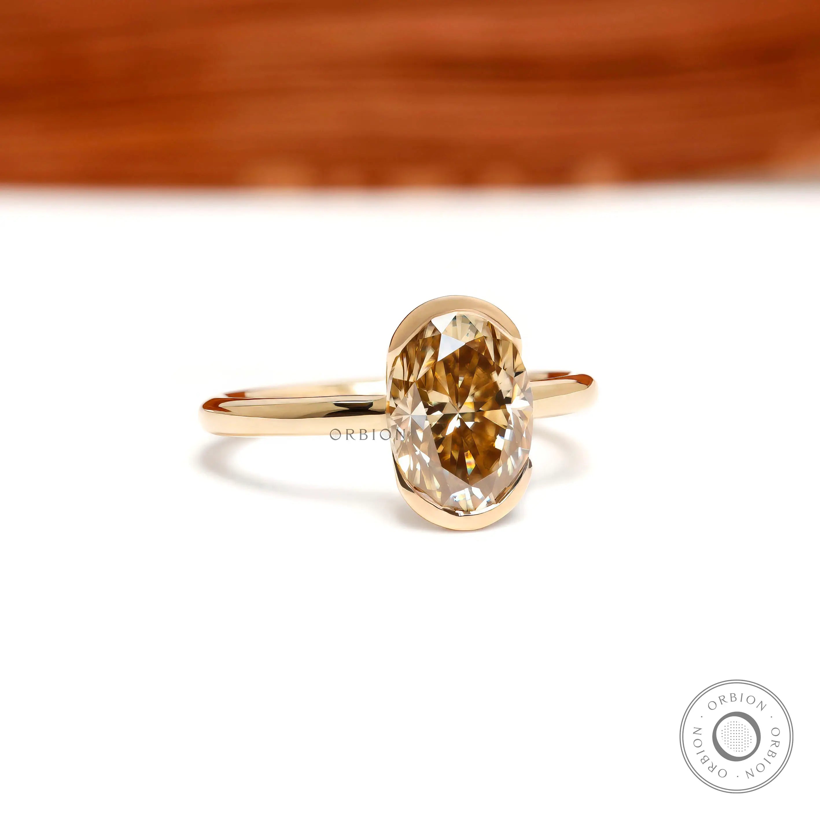 Centered closeup of oval champagne moissanite in floating bezel