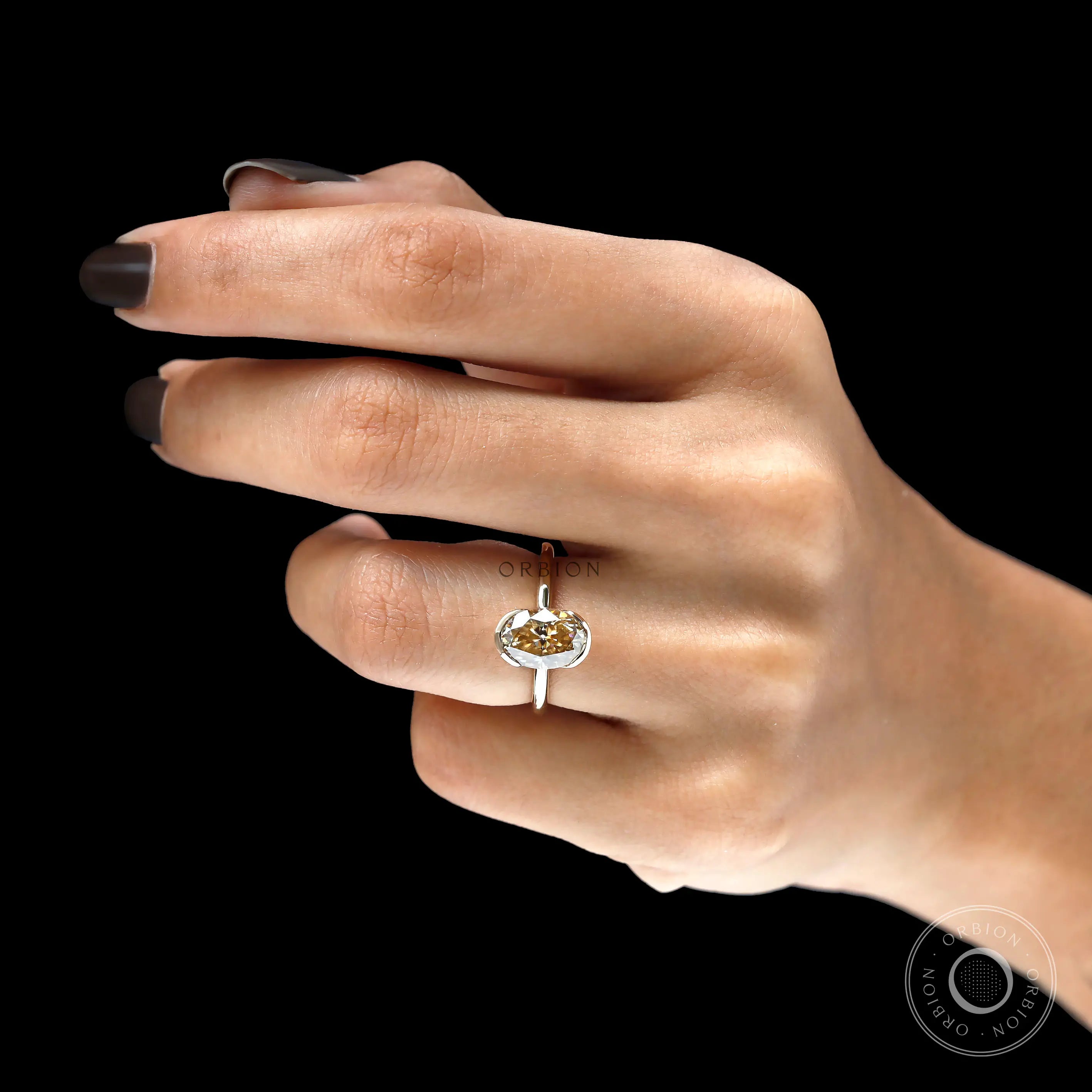 On hand top view of oval champagne moissanite engagement ring