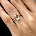 Closeup on hand highlighting oval moissanite and half bezel frame