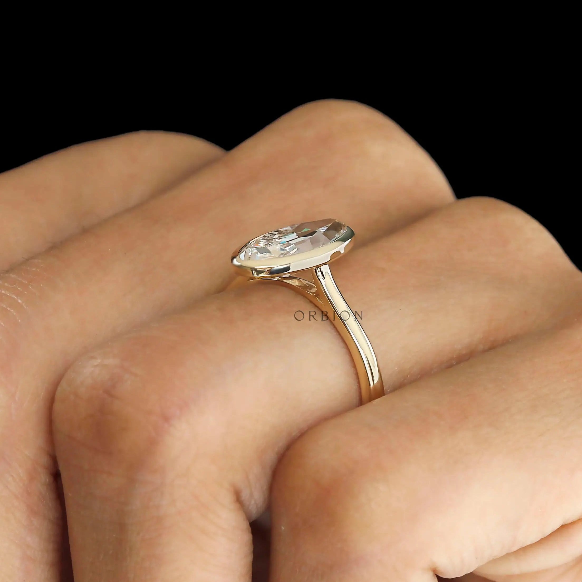 Side hand view elongated moval bezel solitaire ring
