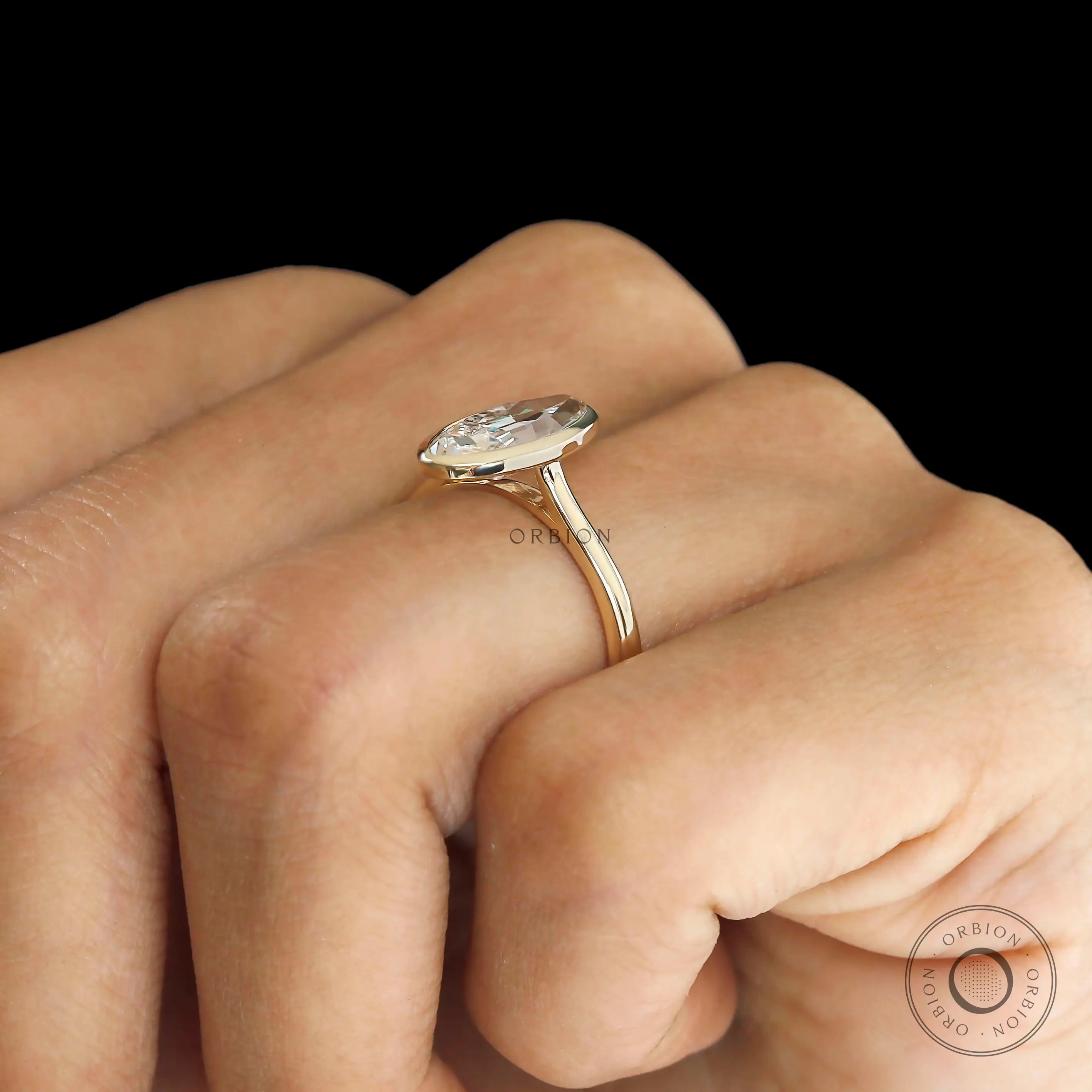 Side hand view elongated moval bezel solitaire ring