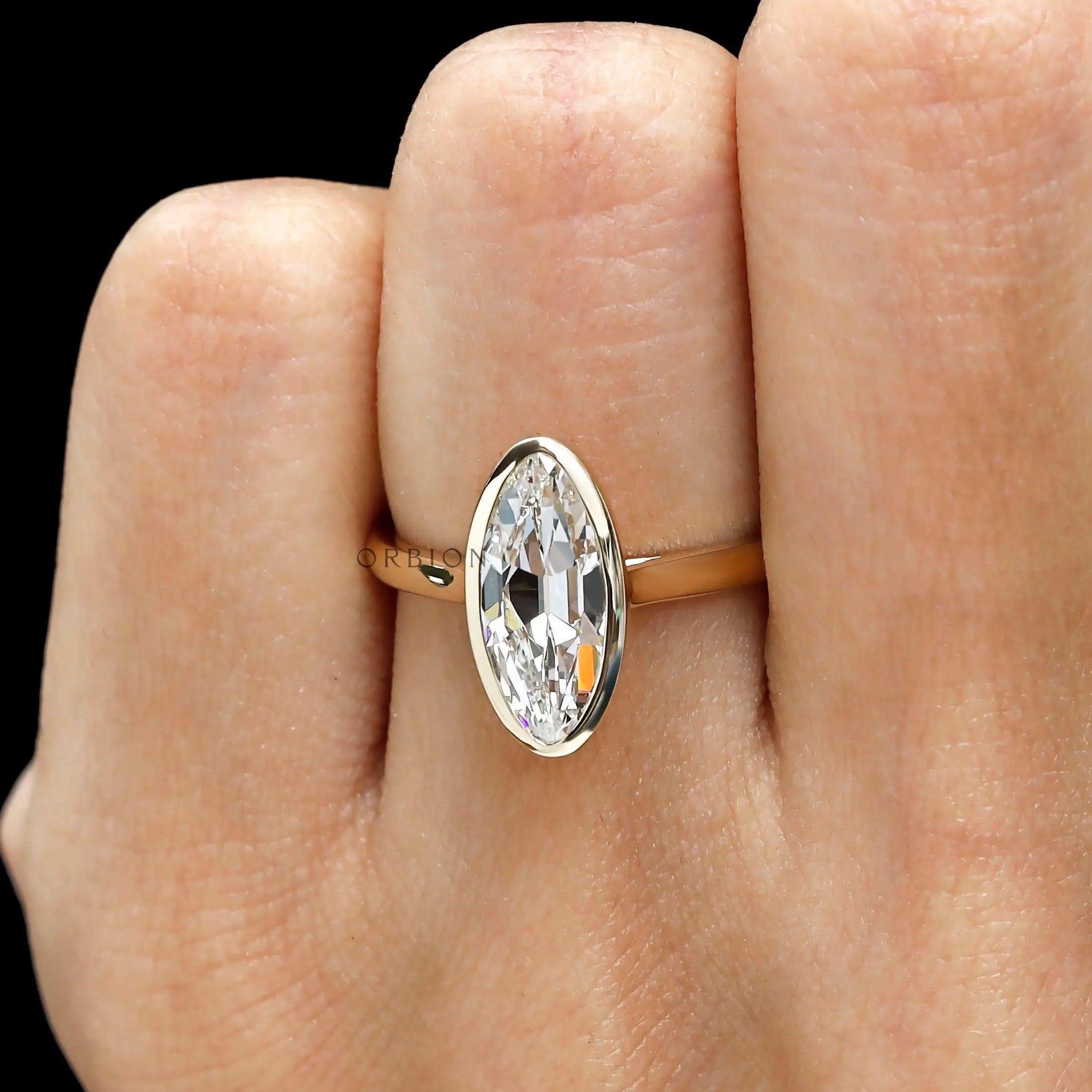 Close hand view elongated moval bezel engagement ring