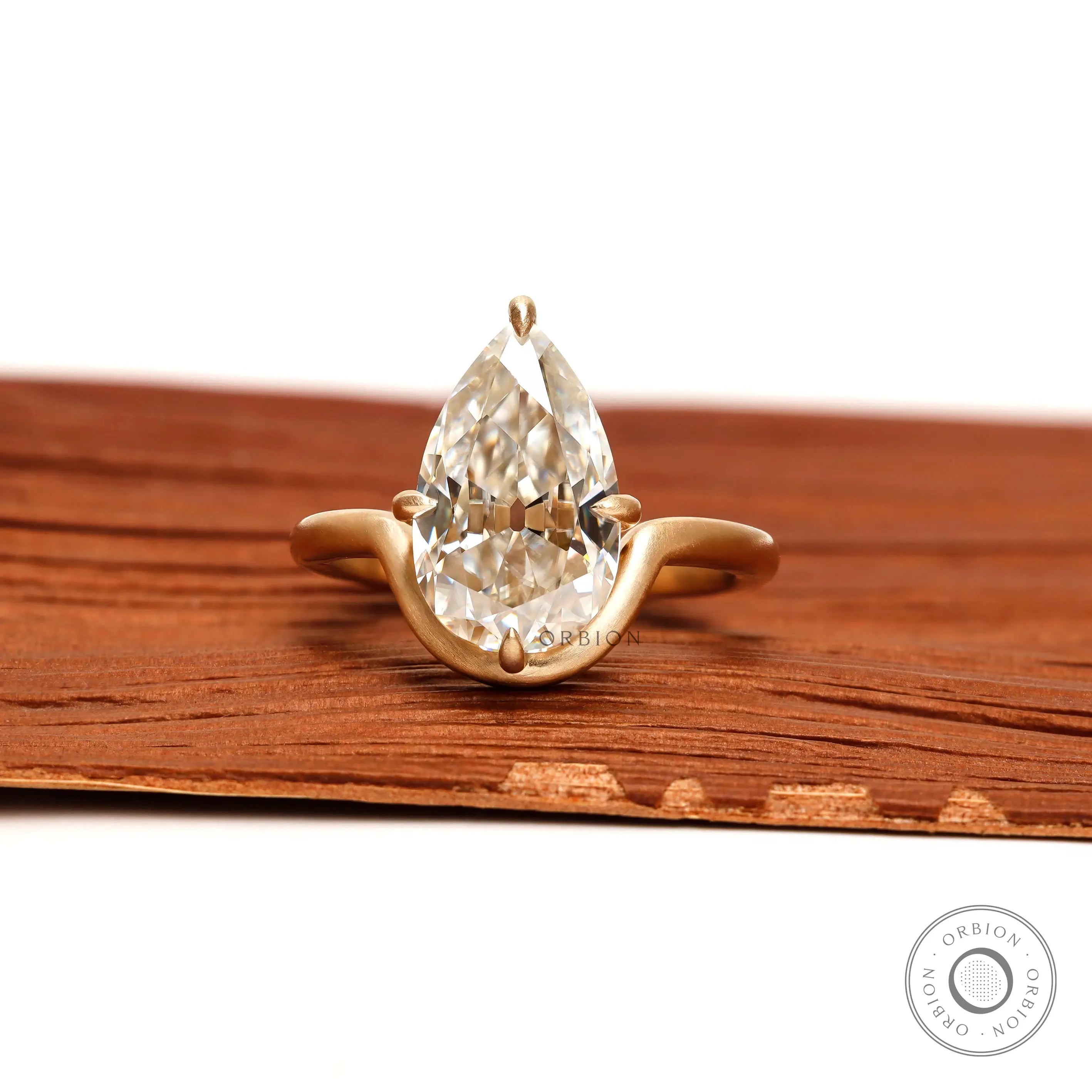 Front view old mine cut pear moissanite bypass ring in matte gold