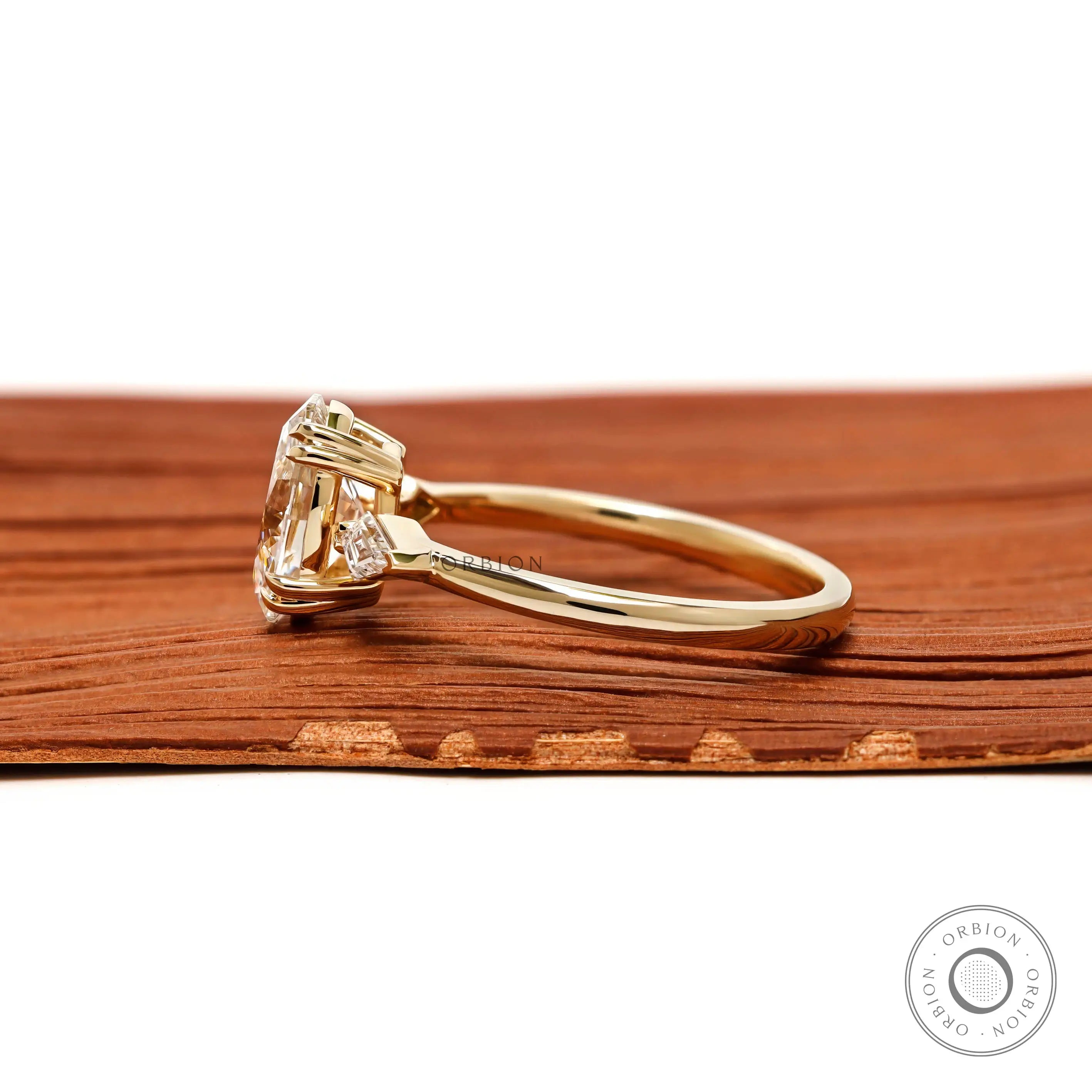 Side profile of oval trilogy ring in yellow gold