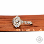 Angled view oval diamond ring with round side stones in gold