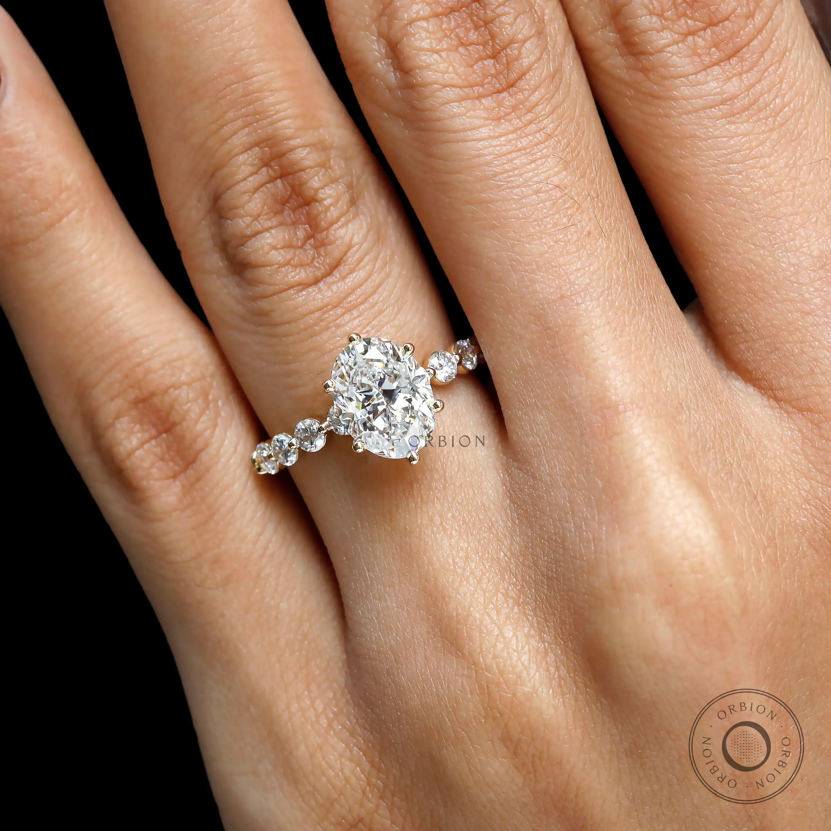 Side angle hand view oval diamond ring in yellow gold