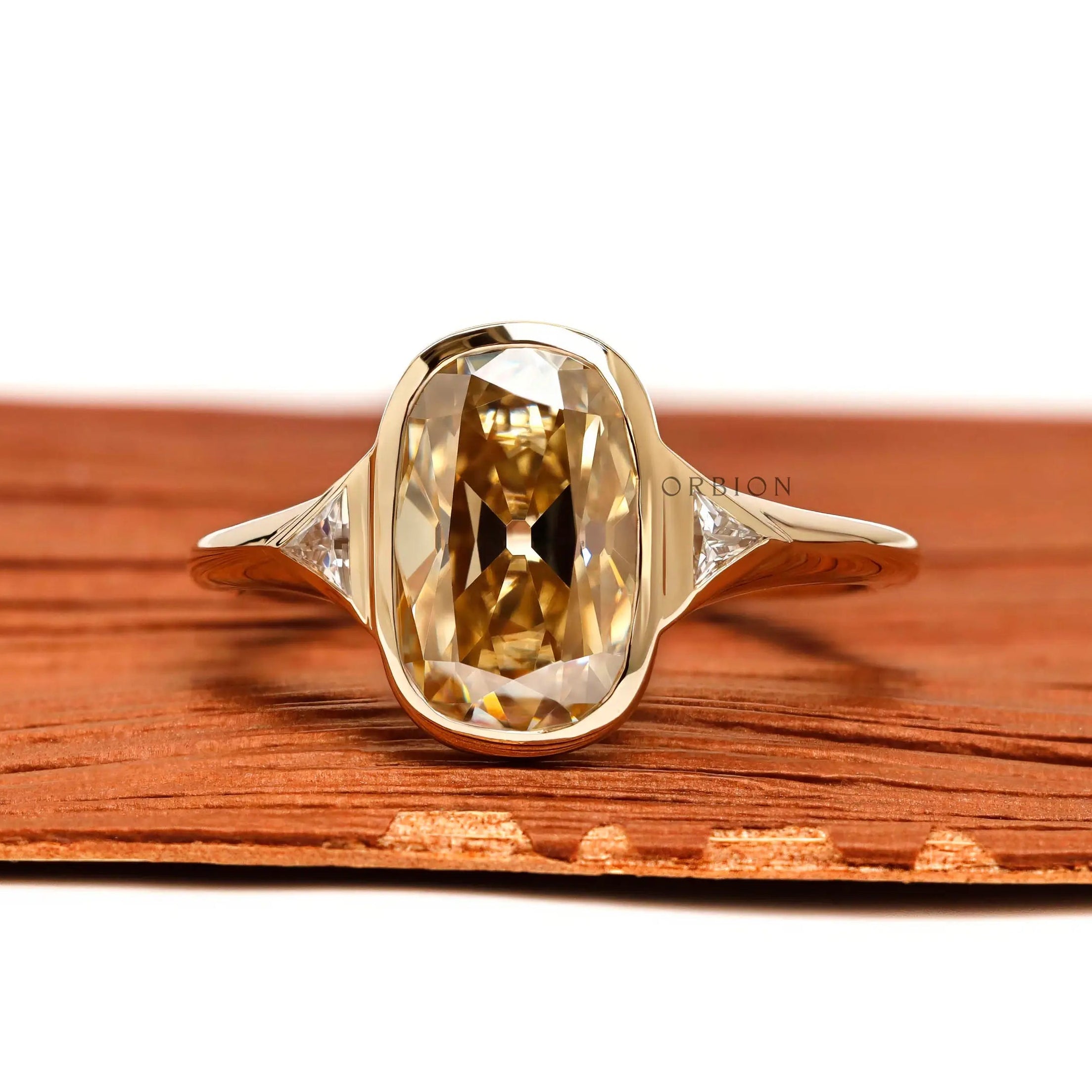 Front view elongated champagne cushion moissanite ring with triangle side stones