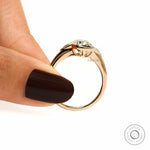 Finger held side view champagne moissanite ring with raised gallery