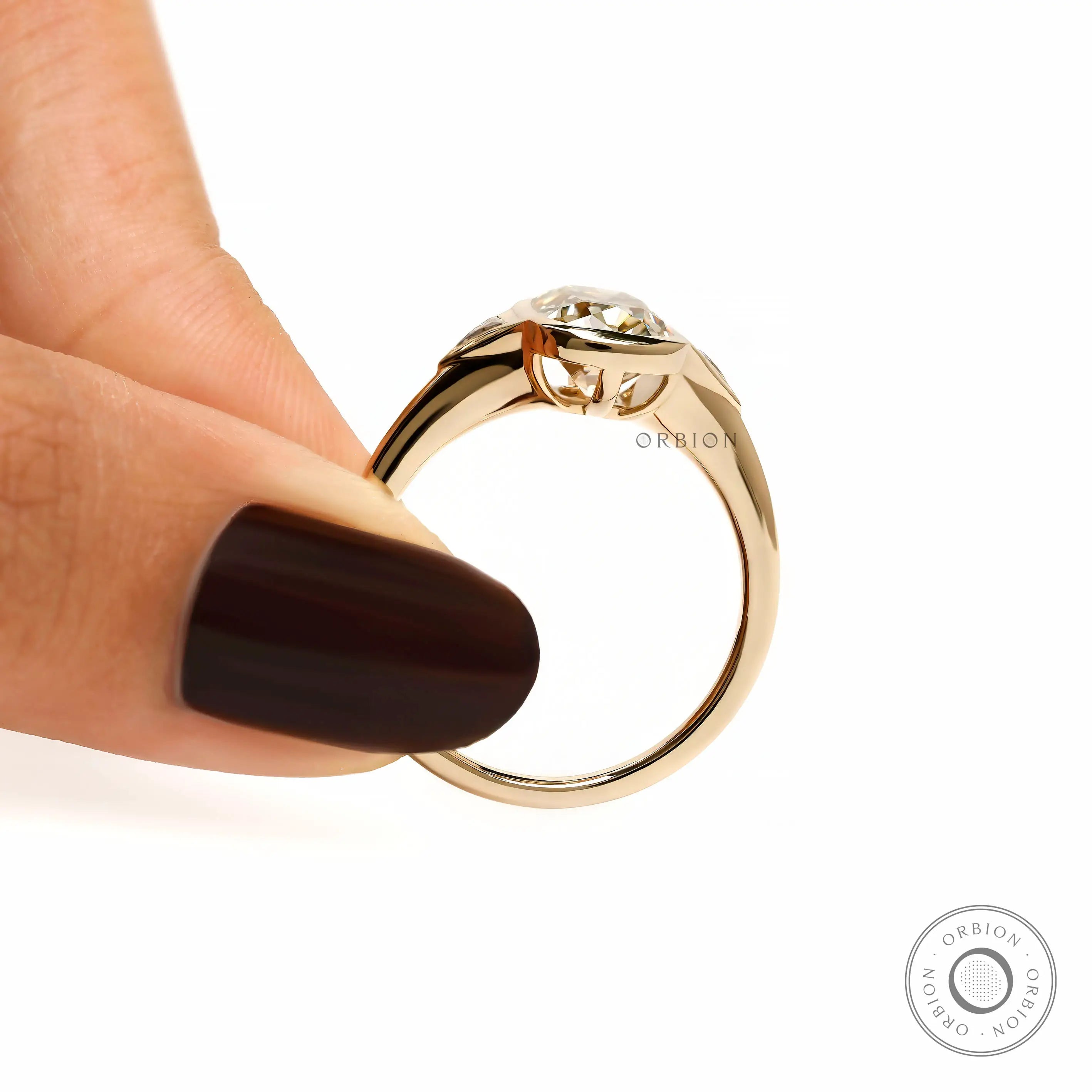 Finger held side view champagne moissanite ring with raised gallery