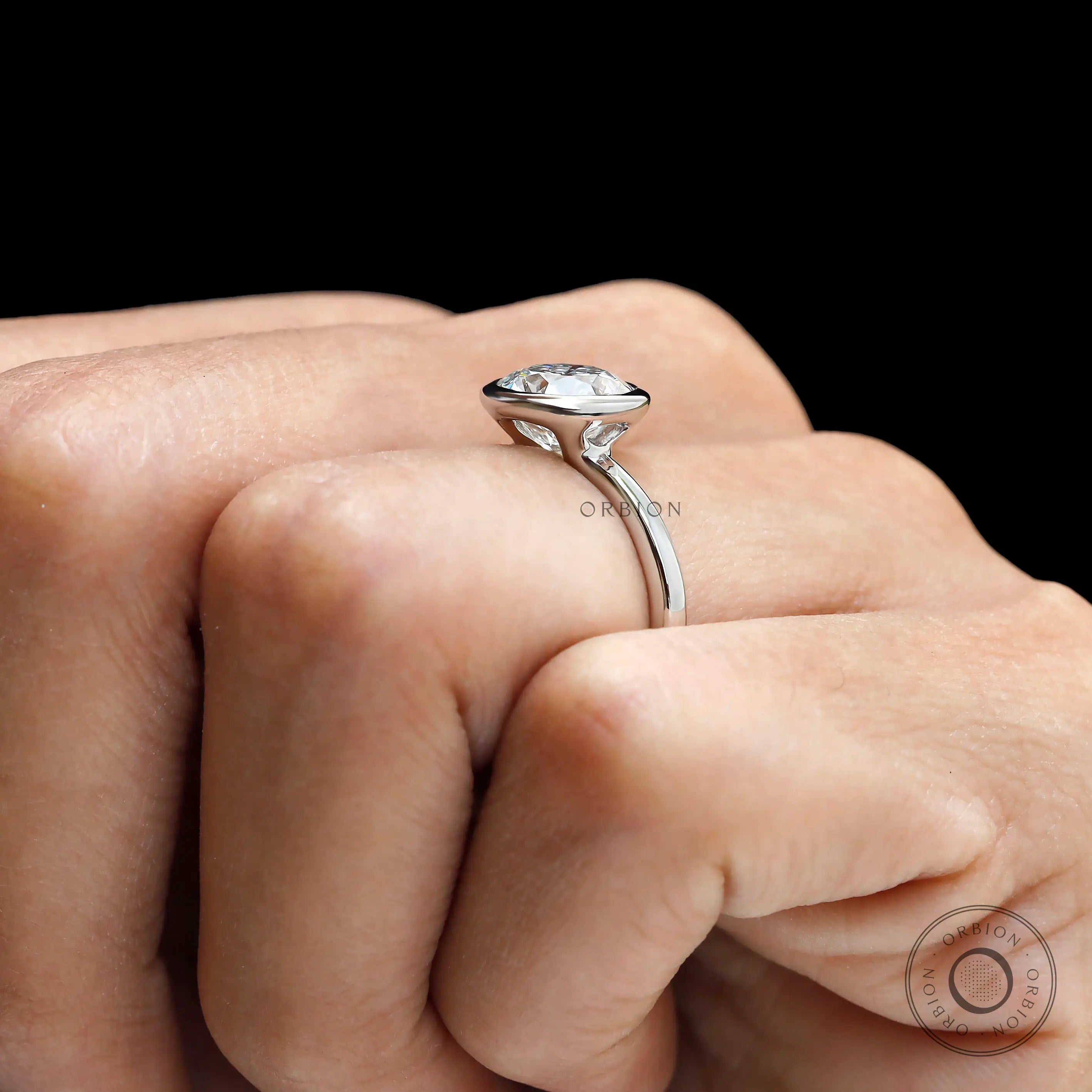 Side hand view elevated bezel set round diamond ring