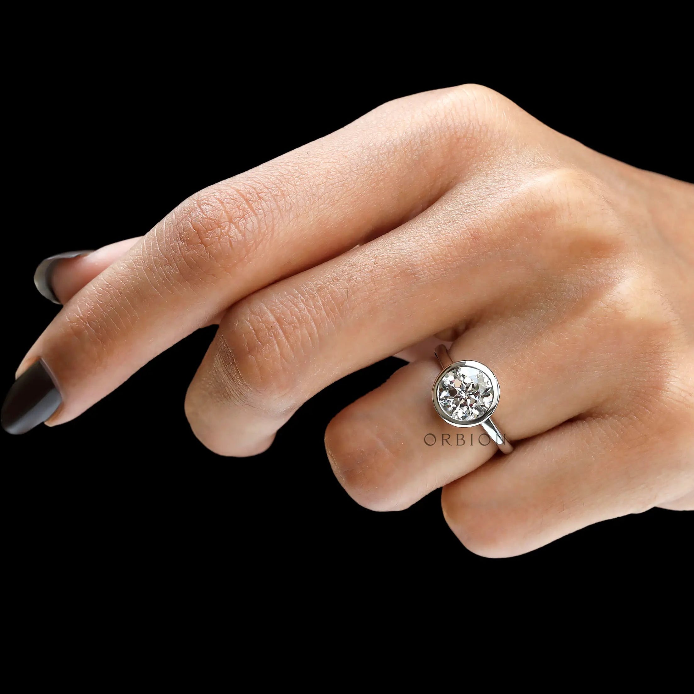 Angled hand view floating bezel round solitaire diamond ring