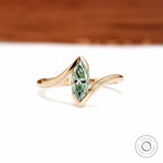 Front View of green marquise lab diamond half bezel ring in yellow gold.