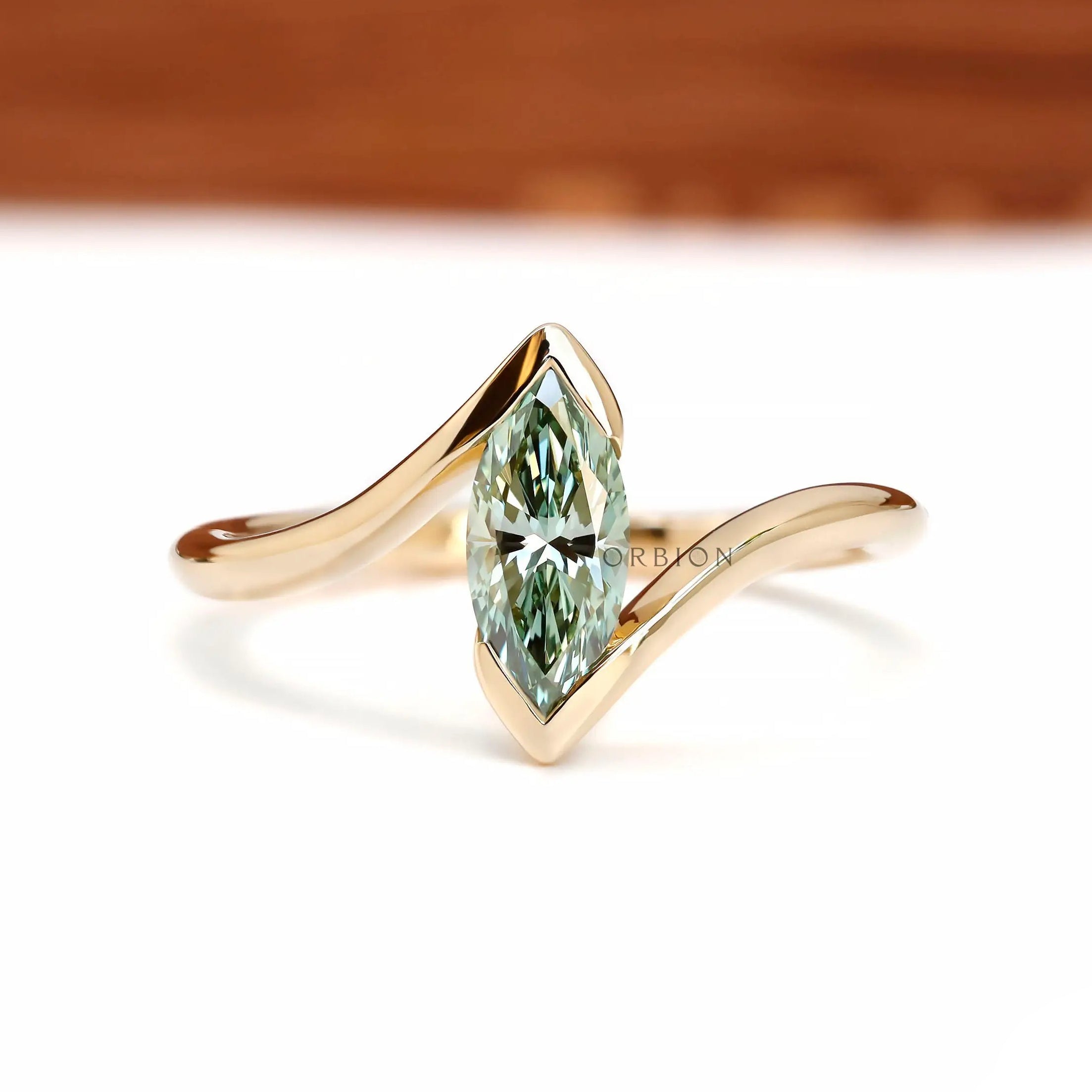 Front View of green marquise lab diamond half bezel ring in yellow gold.