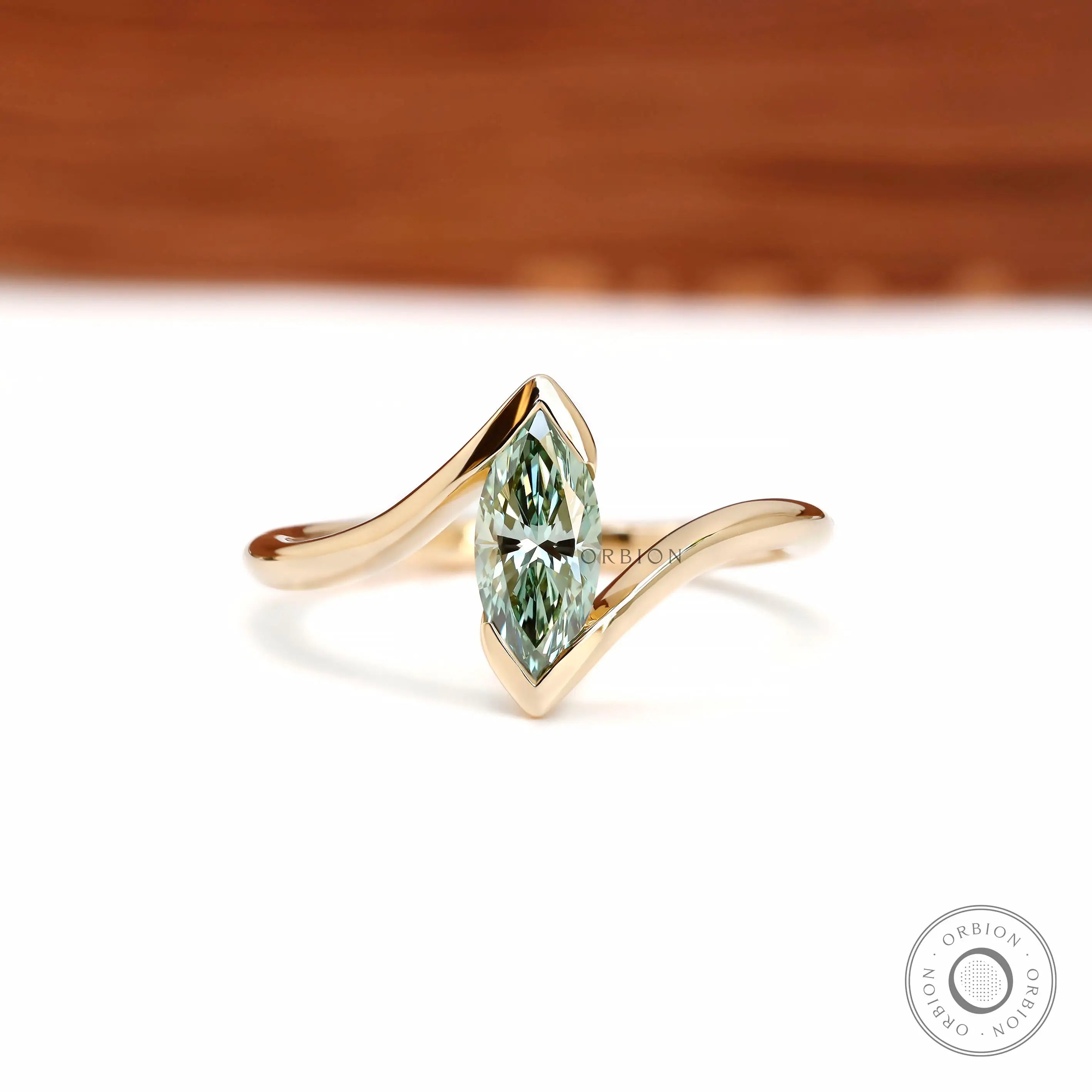 Front View of green marquise lab diamond half bezel ring in yellow gold.