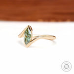 Angled front view of marquise green lab diamond bypass ring in yellow gold.