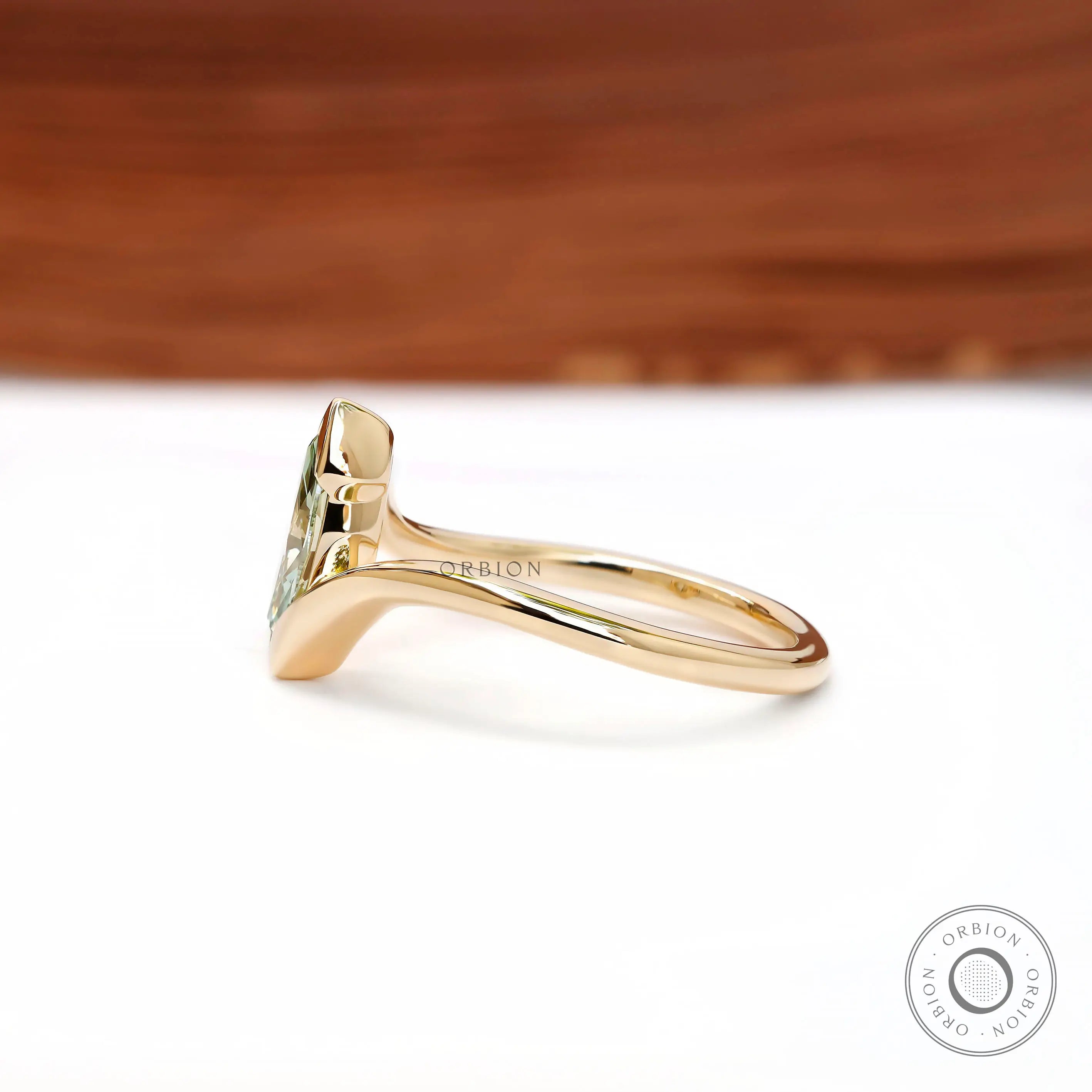 Side profile of dainty marquise lab diamond half bezel engagement ring.