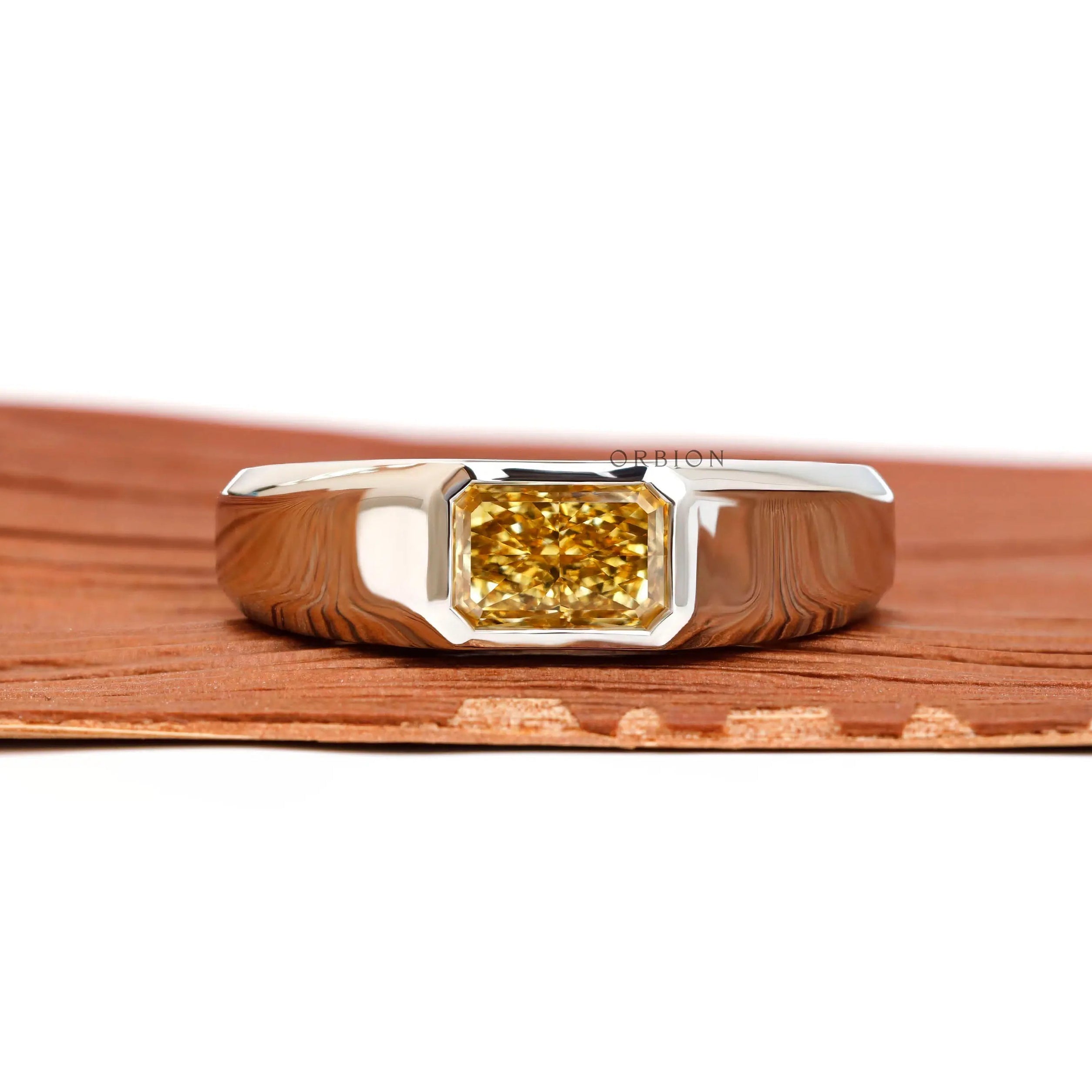 Front view platinum signet ring with east west radiant yellow lab diamond.