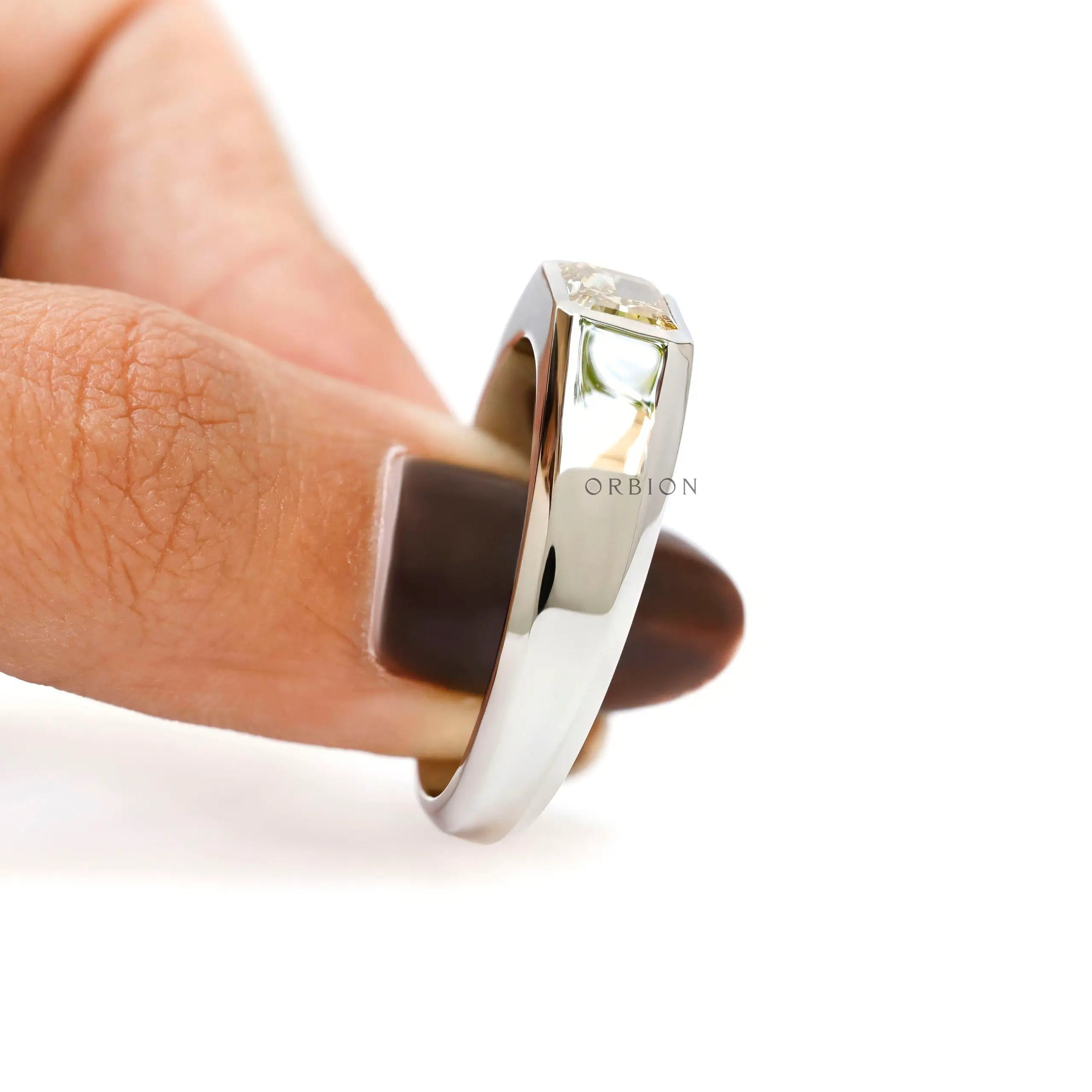 Angled finger hold view emphasizing raised radiant diamond setting.