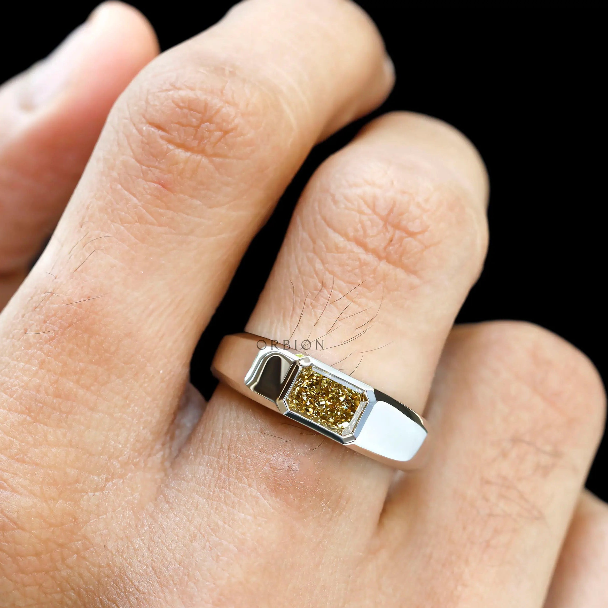 Front view of radiant yellow diamond platinum signet ring worn.