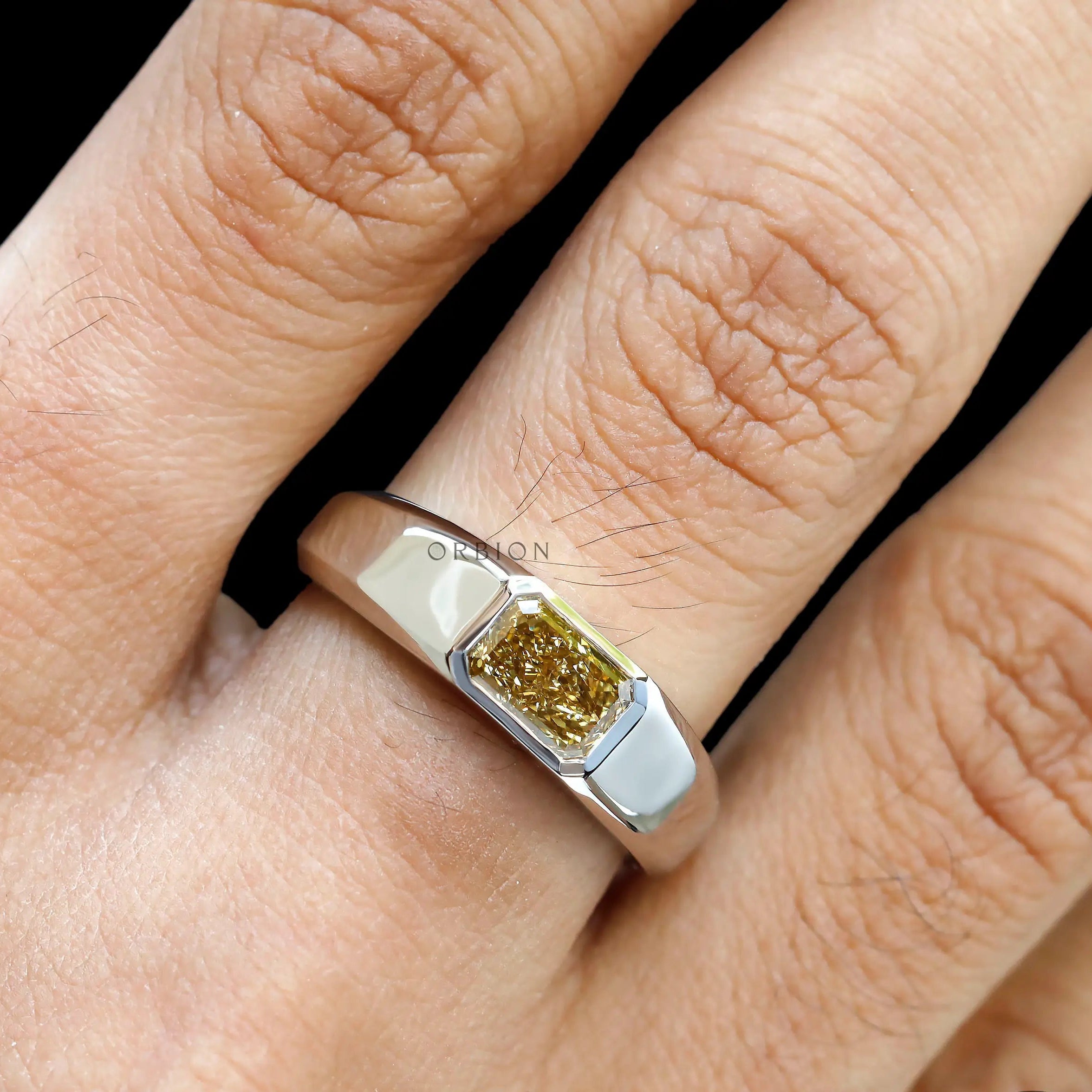Close up worn view highlighting radiant yellow diamond center stone.