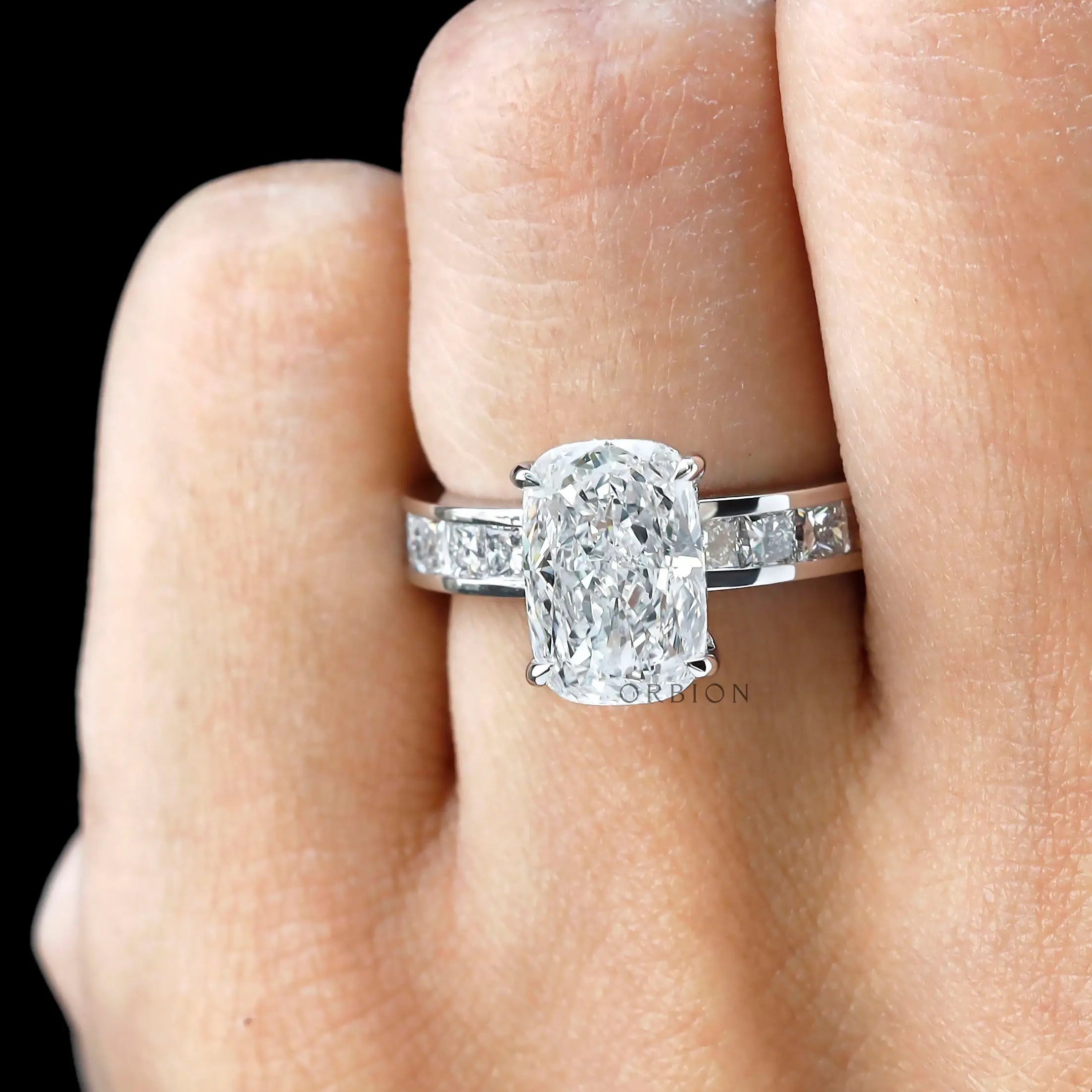 Close worn view elongated cushion diamond ring with channel band.