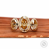 Front view three stone bezel set champagne oval moissanite ring.