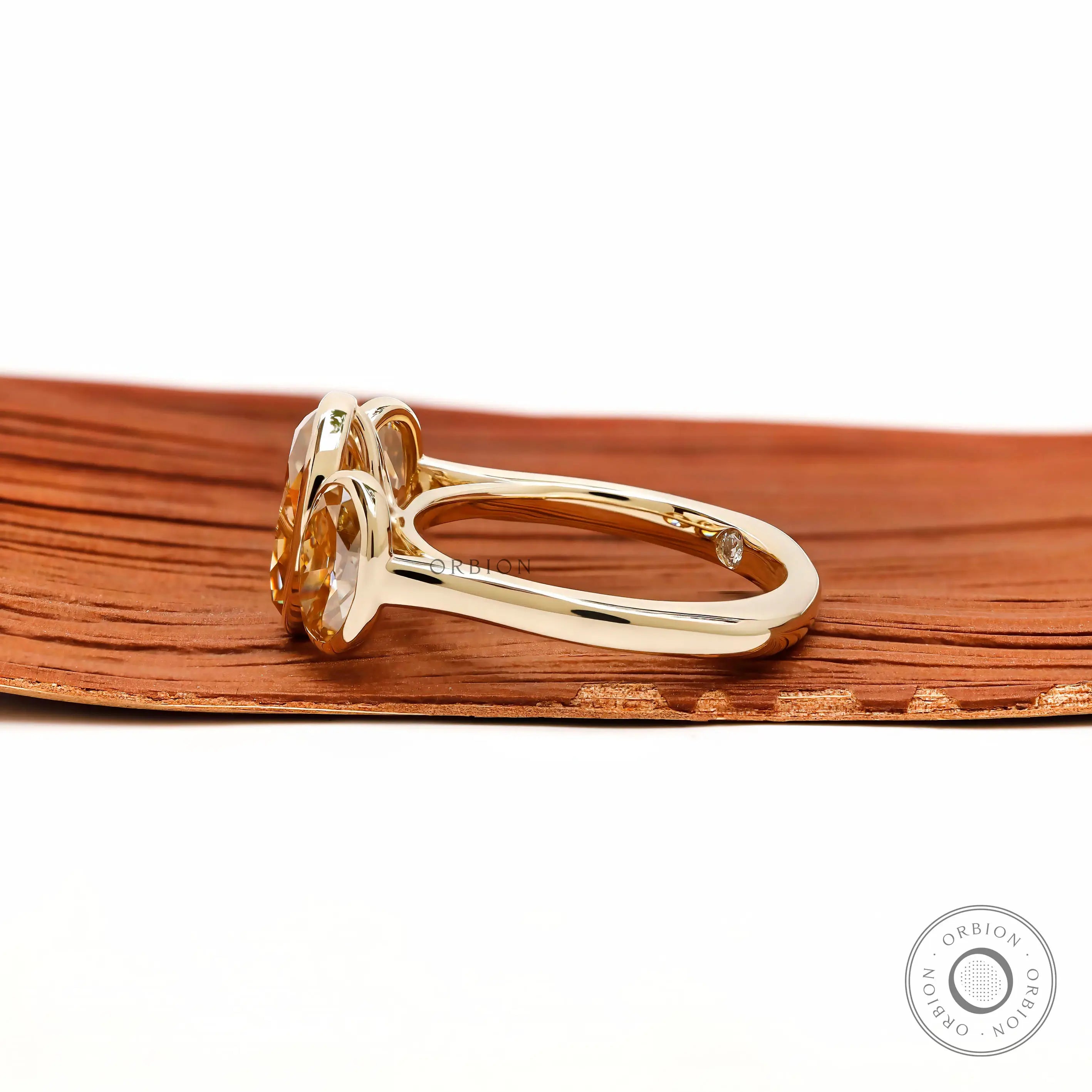 Side profile showing raised bezel ovals and yellow gold band.