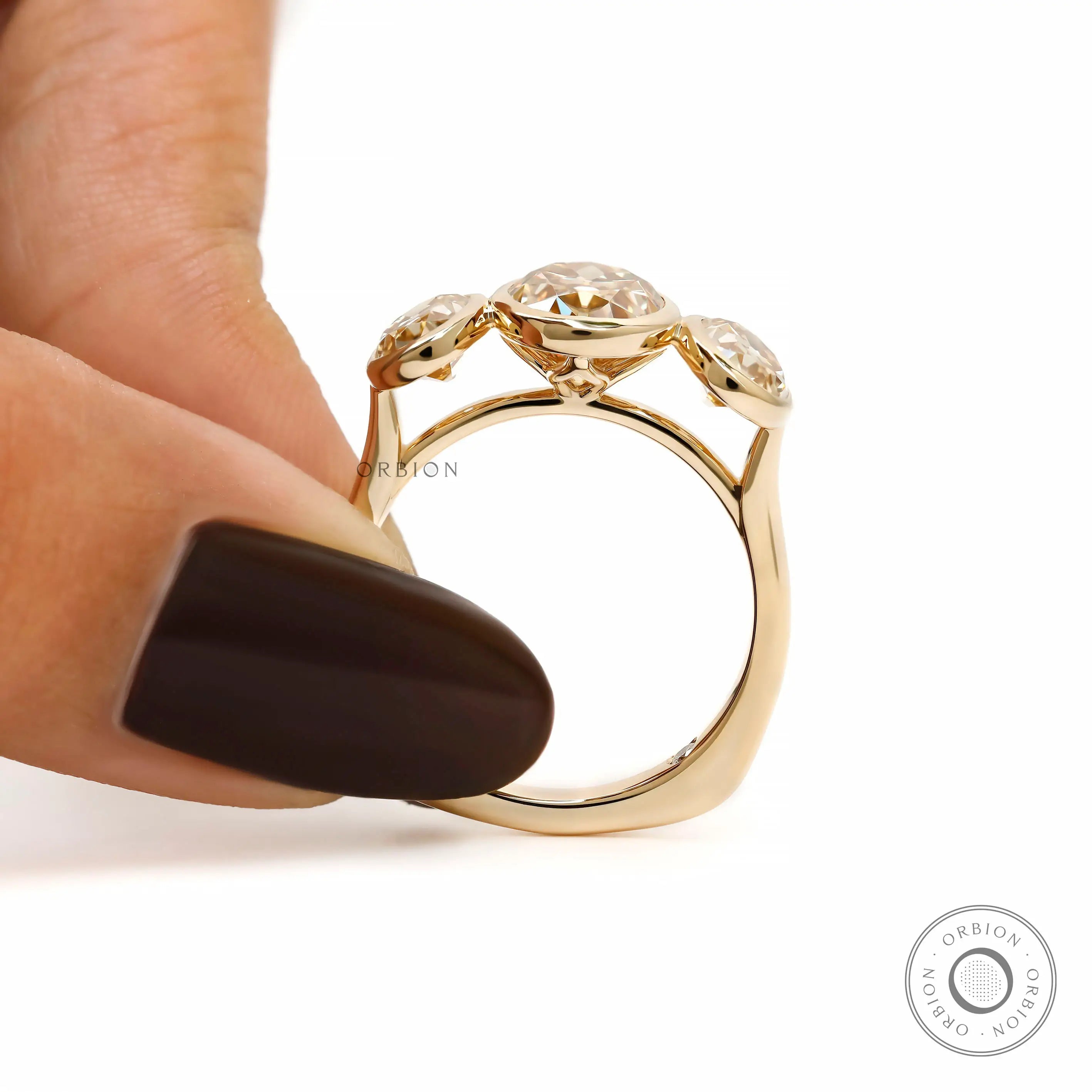 Held side view showing elevated oval bezels and tapered shank.