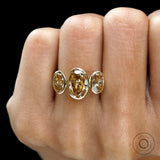 Front worn view of bezel set oval three stone ring.