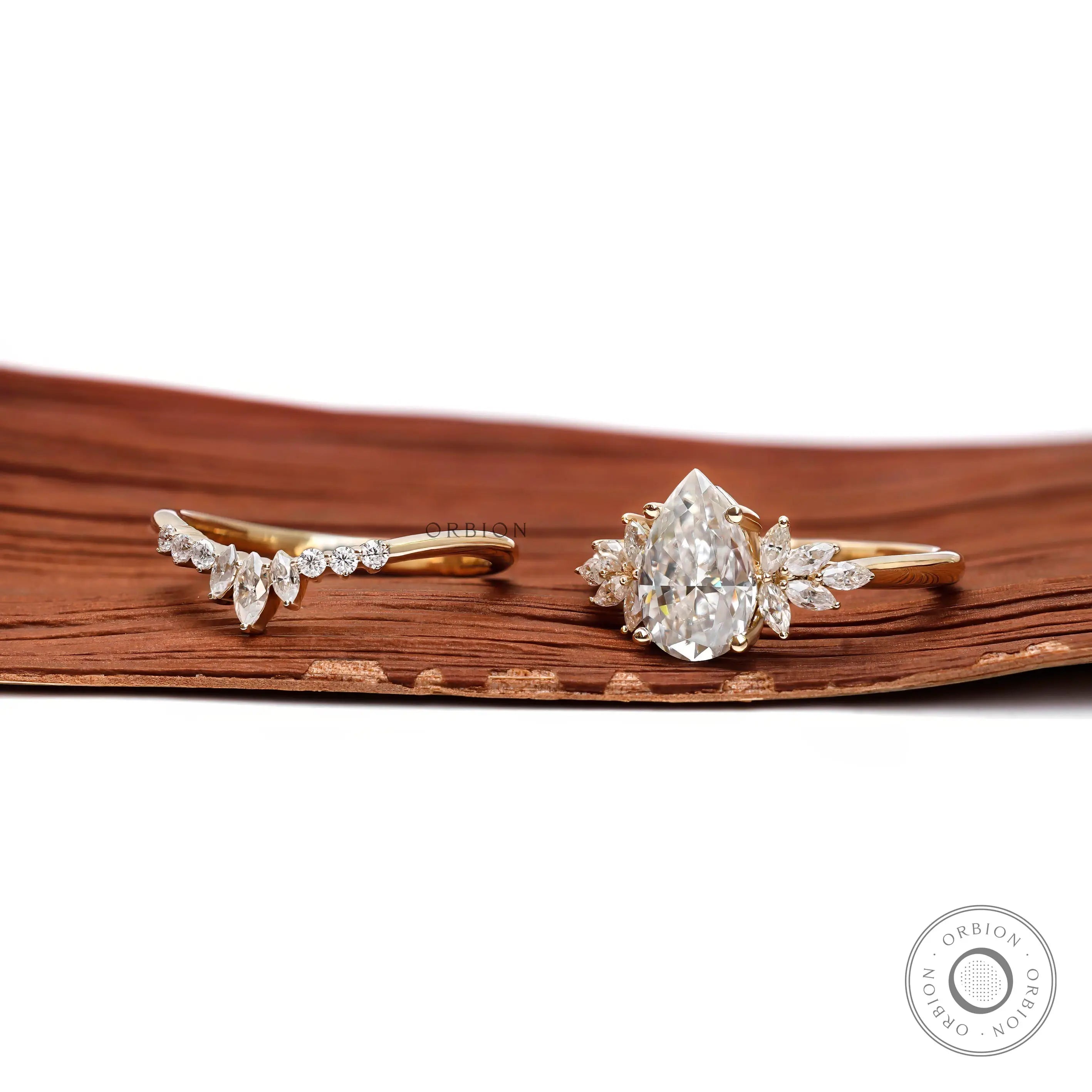 Angled front view of pear moissanite cluster ring set